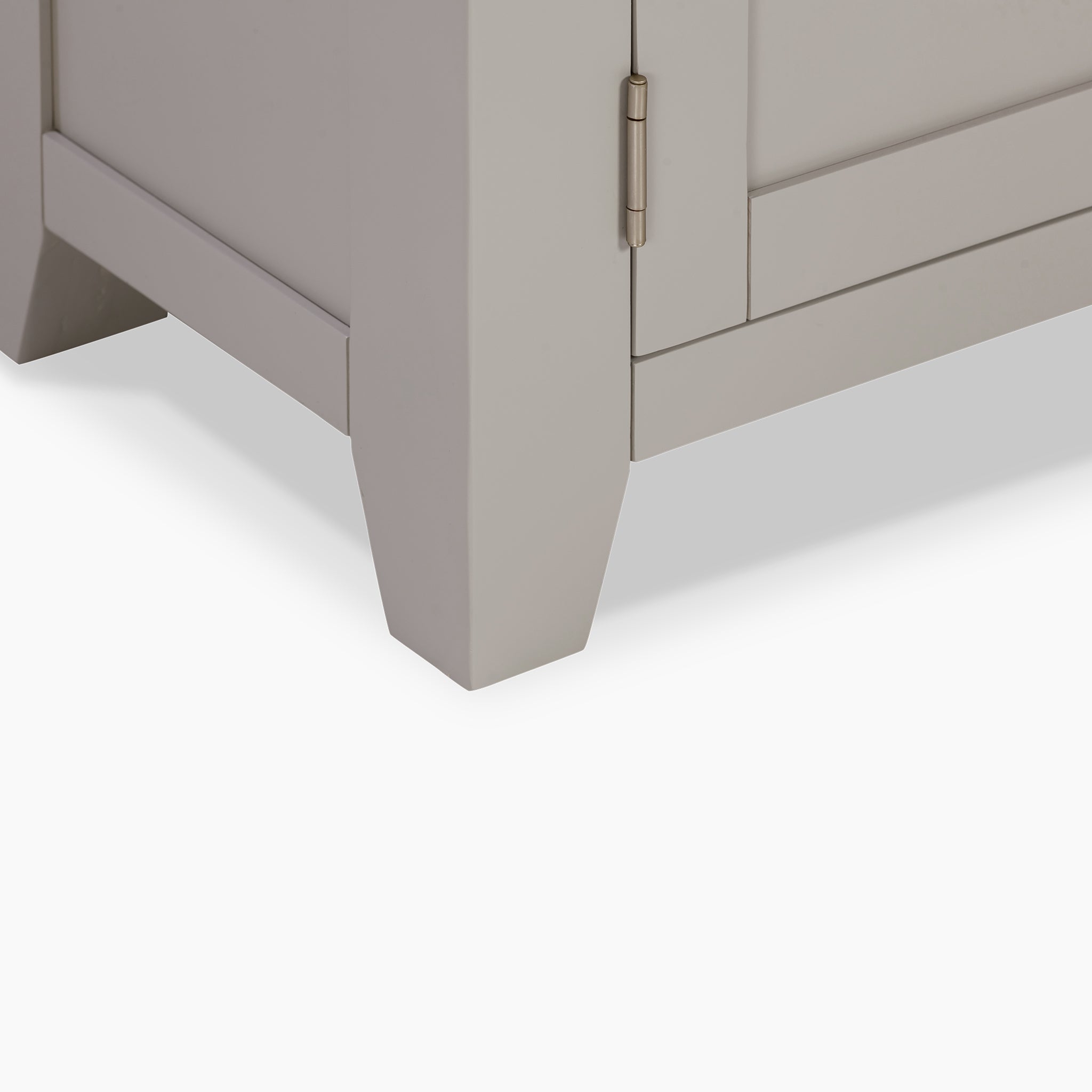 Close-up of a corner of the Burford Large 180cm Media Unit in Pebble Grey, showcasing its visible hinge and angled legs that elegantly complement its overall design.