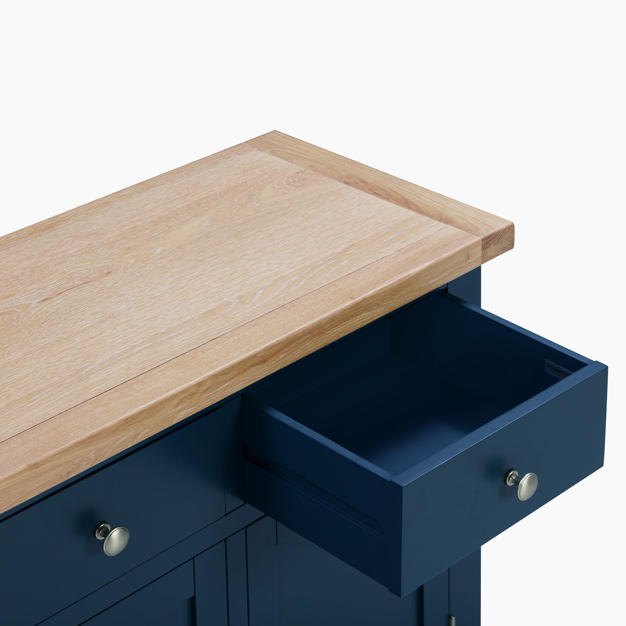 The Burford 2 Door 2 Drawers Sideboard in Navy Blue showcases a drawer slightly open, accentuating its immaculate natural oak top surface.