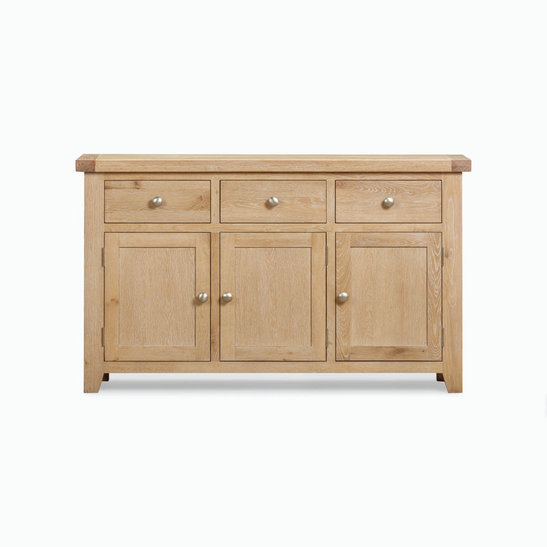 The Burford Large 3 Door 3 Drawers Sideboard in Natural Oak, featuring three drawers on the top row and three cabinets below, each with a knob handle, offers ample storage.