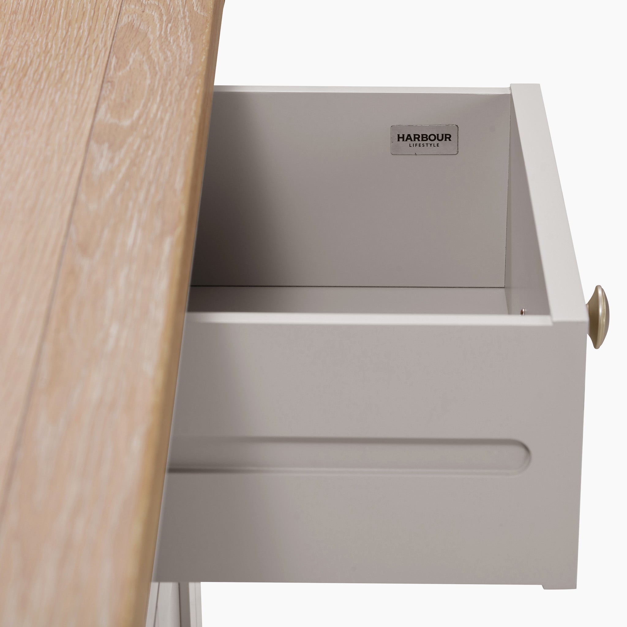 Open pebble grey drawer with a natural oak top and label reading "Harbour Lifestyle" inside.