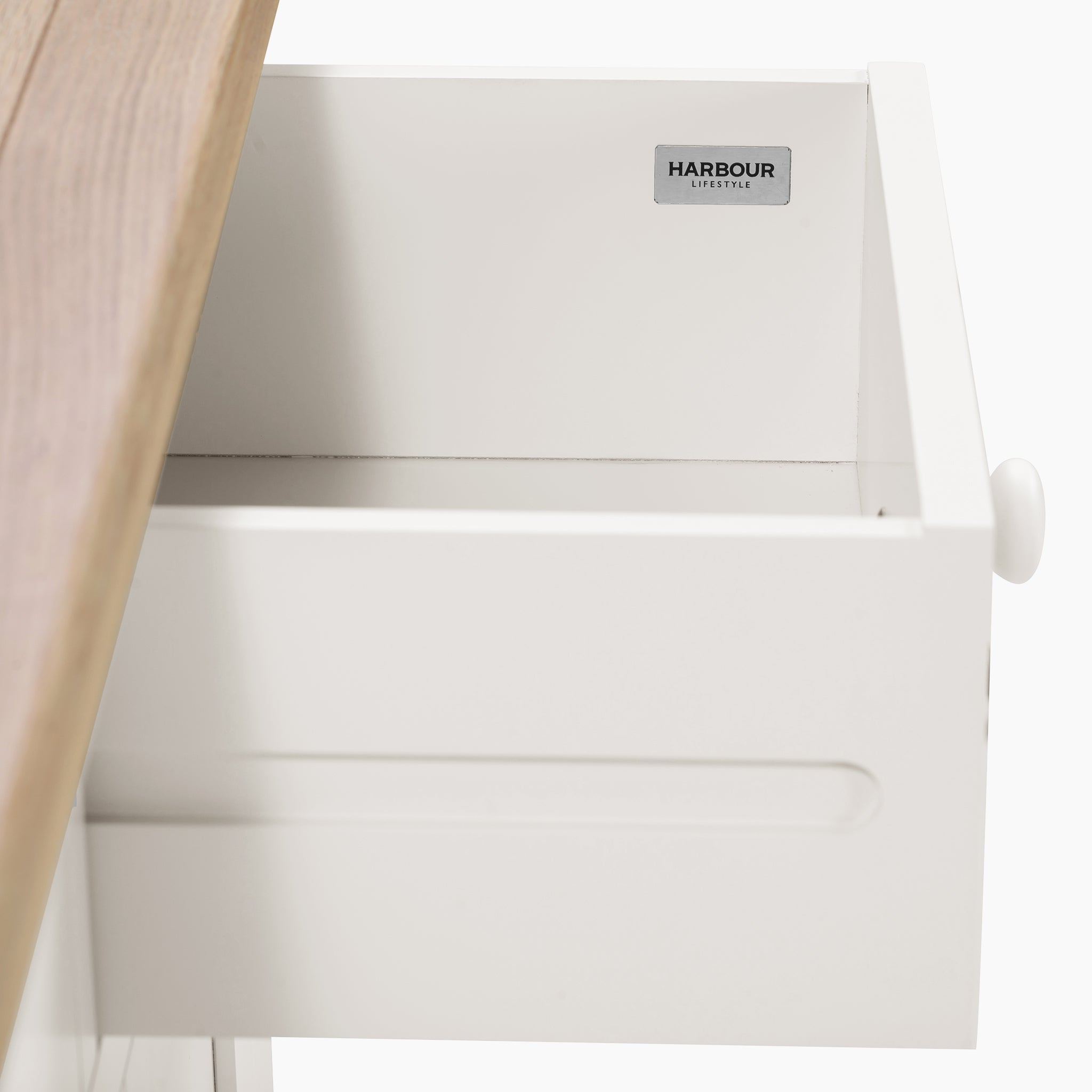 Open the white drawer with a natural oak wooden countertop, featuring the "Harbour Lifestyle" label inside for ample storage. It perfectly complements the Burford Large 3 Door 3 Drawers Sideboard in Warm White for a seamless look.