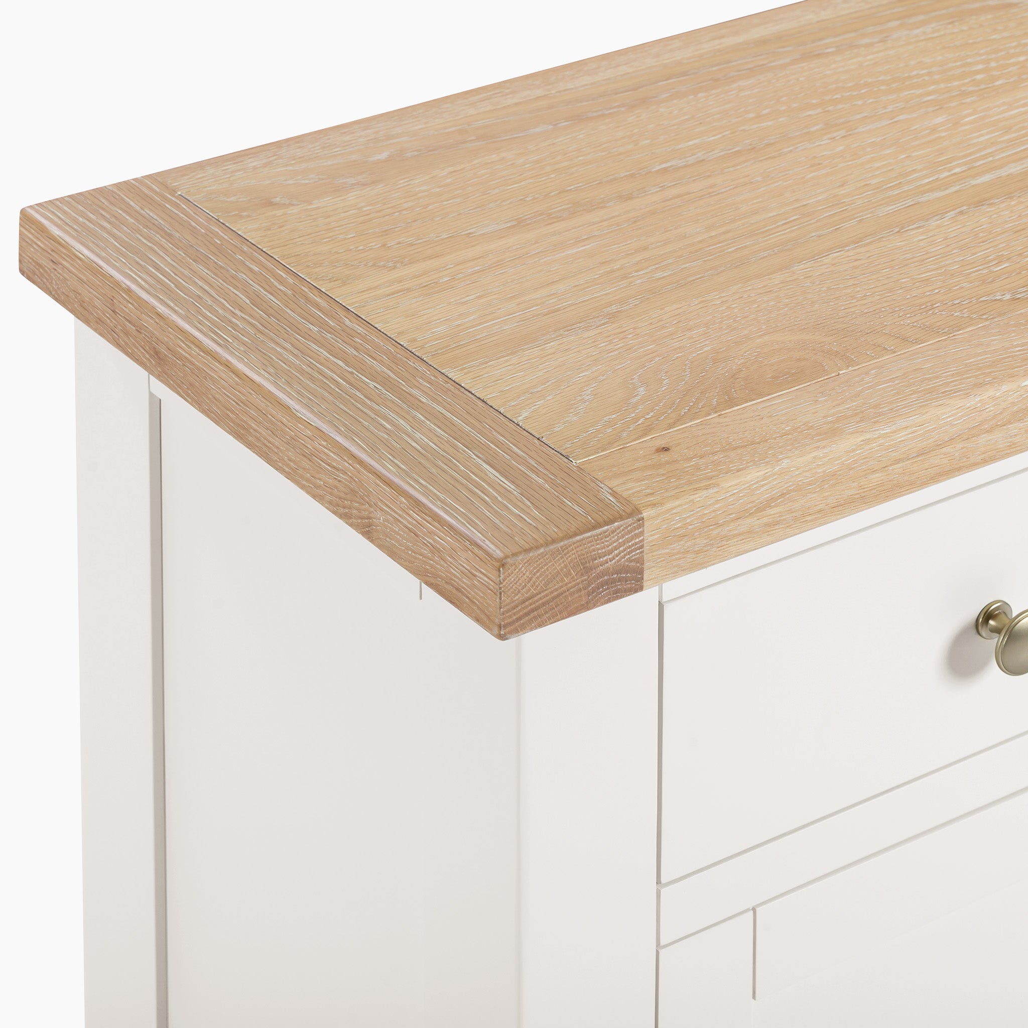 Close-up of a Burford Large 4 Door 3 Drawers Sideboard in warm white, showcasing a light natural oak top and a silver knob on the storage drawer.