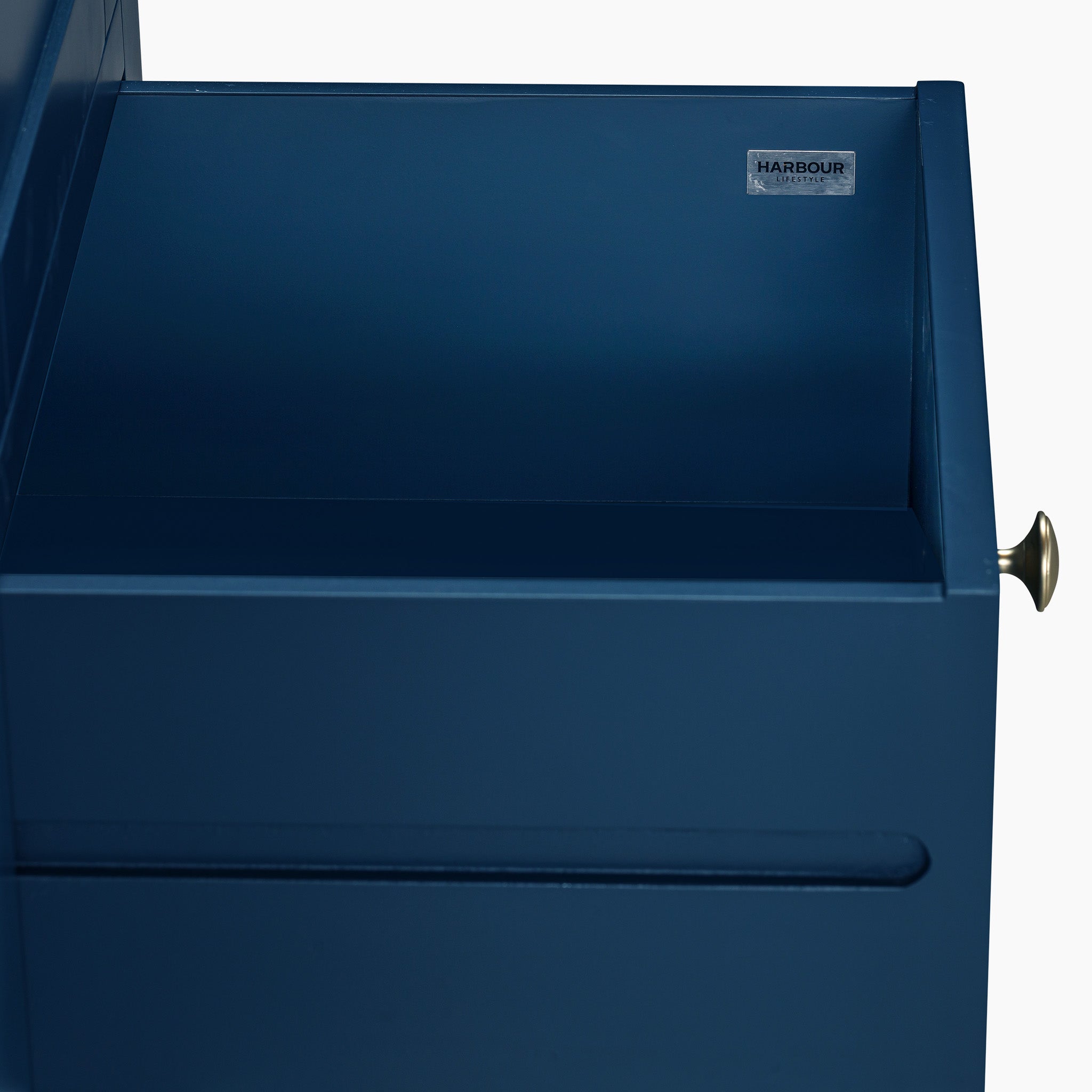 A partially open drawer with a metal handle and a label reading "Harbour" complements the solid oak top of the Burford Triple Larder Unit in Navy Blue.