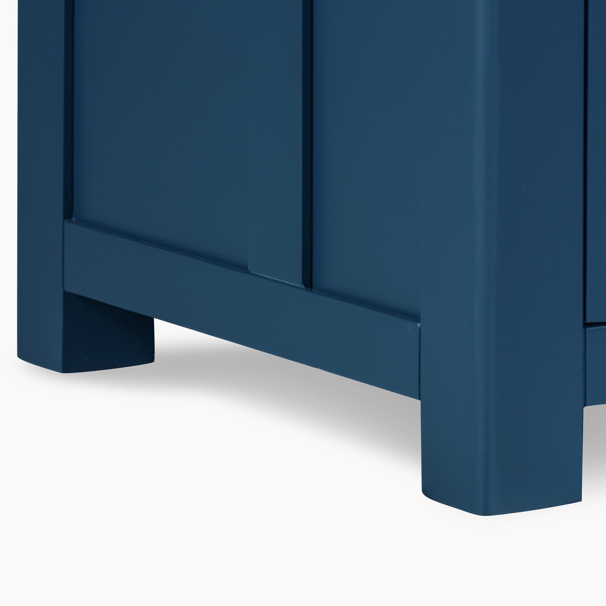 The Burford Triple Larder Unit in Navy Blue showcases a detailed view of its cabinet corner, highlighting smooth, clean lines and a matte finish, completed by a solid oak top.