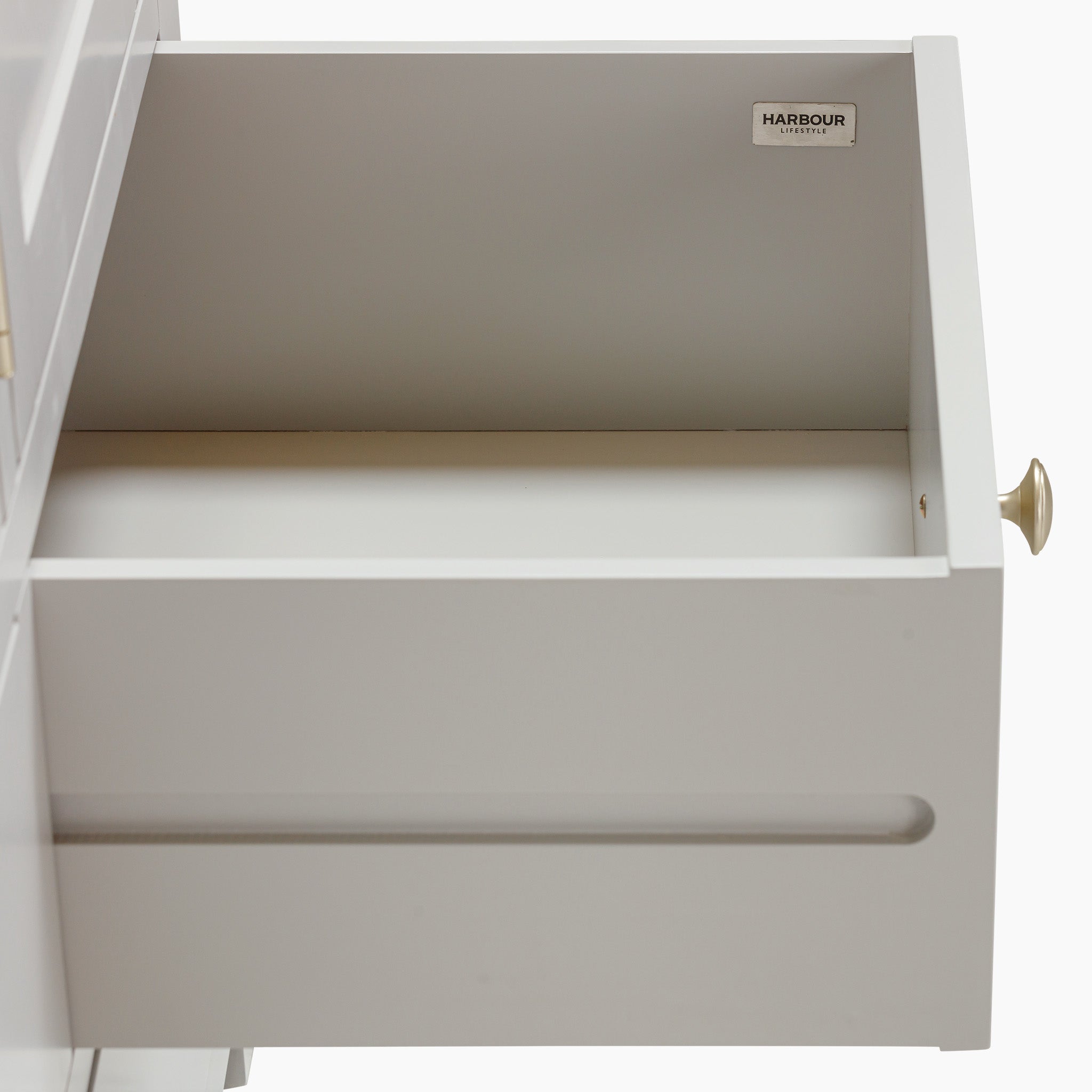 Open white drawer with a brass knob, revealing an empty interior that complements any modern kitchen storage solution. Its minimalistic design pairs well with larger pieces like the Burford Triple Larder Unit in Pebble Grey, creating a harmonious blend of style and functionality in natural oak finishes.