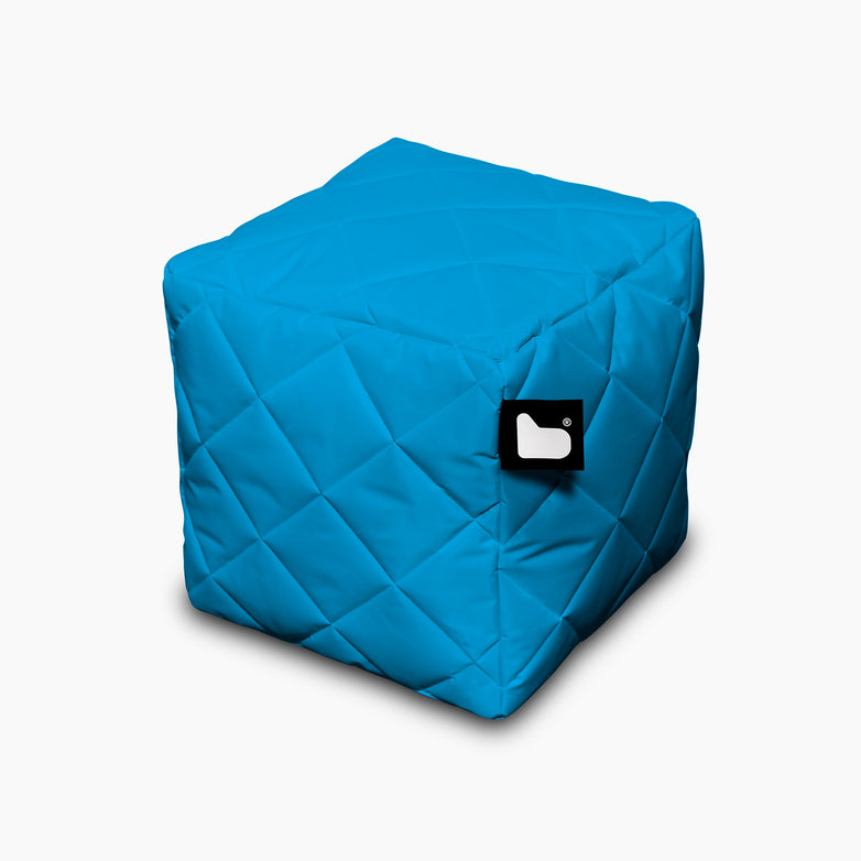 An Outdoor Quilted B-Box in Aqua, cube-shaped with a black-and-white tag on the side, perfect for extreme lounging against a white background.