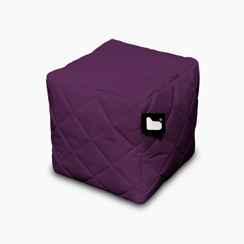 An Outdoor Quilted B-Box in Berry, perfect for extreme lounging, featuring a small black tag with a white logo.