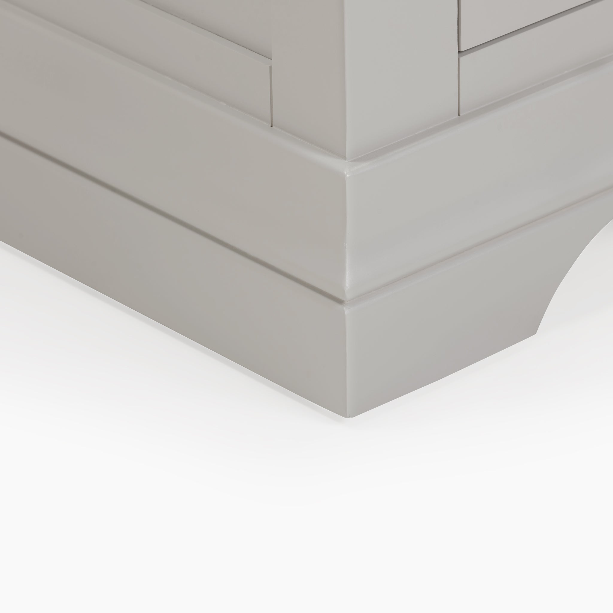 A close-up view of the Chalbury 3 Drawer Bedside Table in Pebble Grey highlights its sleek, glossy finish and intricate base design.