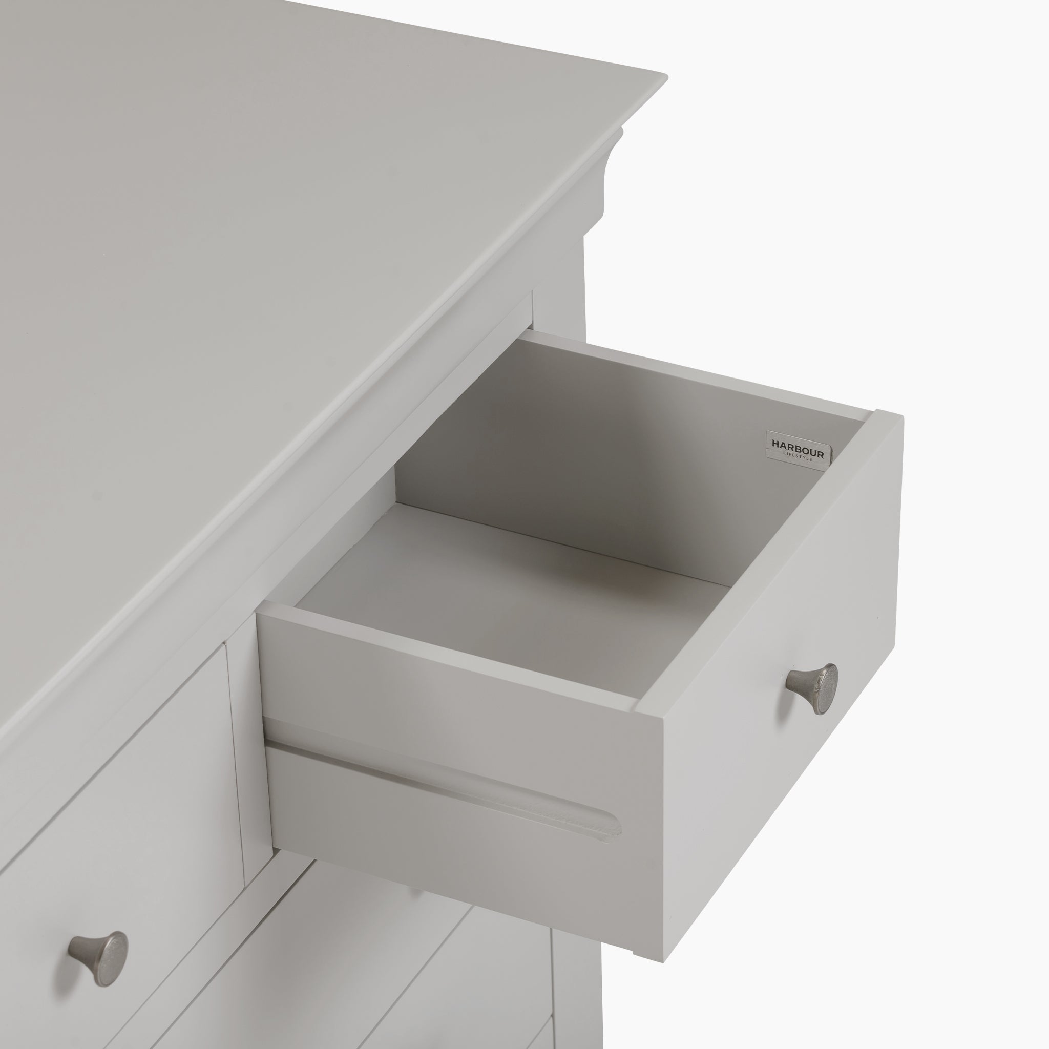 The Chalbury 2 Over 3 Chest of Drawers, in a stylish Pebble Grey, showcases a modern design with an open drawer that highlights its generous interior space.