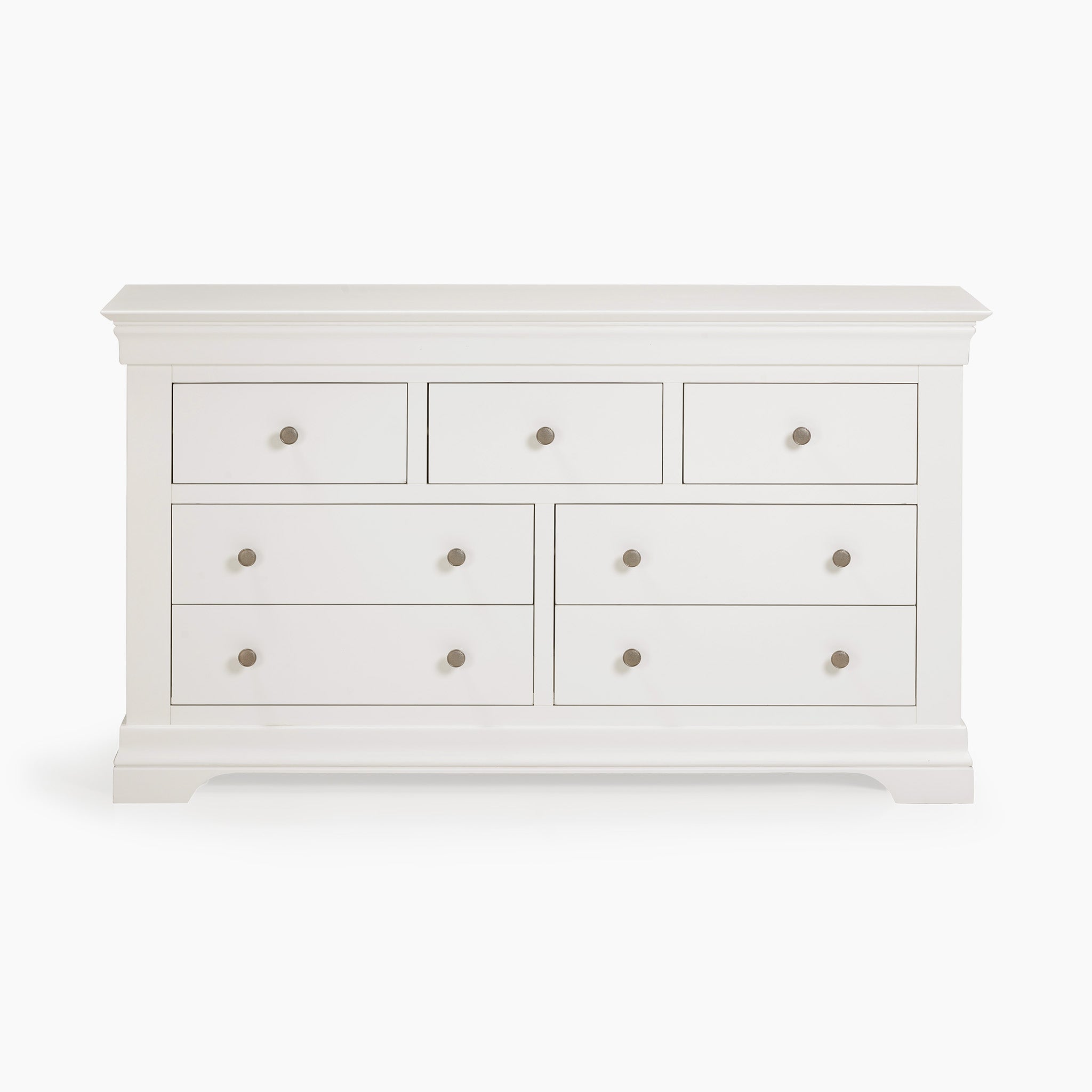 The Chalbury 3 Over 4 Chest of Drawers in Warm White features seven spacious drawers adorned with elegant silver knobs, offering ideal storage that effortlessly complements any interior on a simple background.