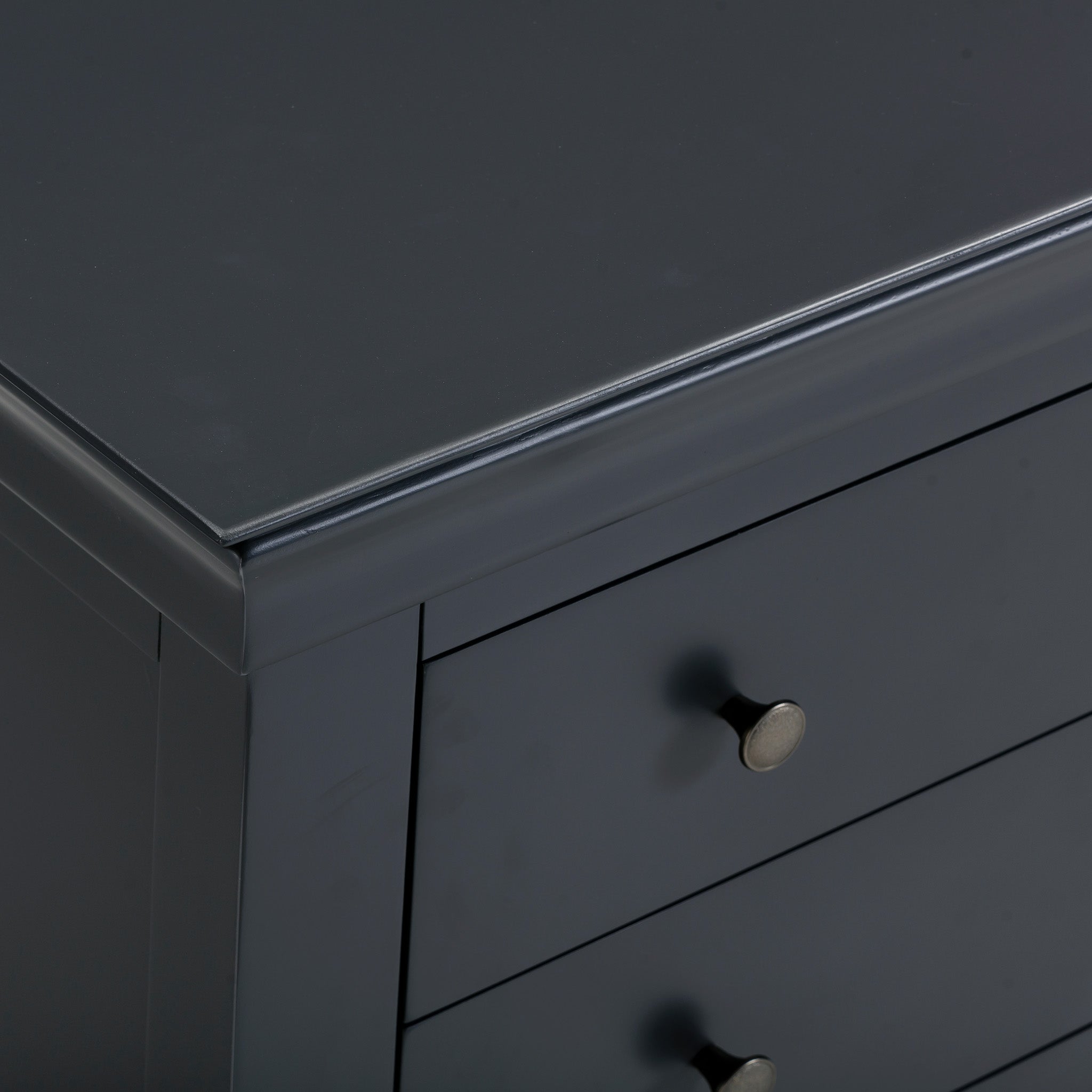 A close-up view of the Chalbury 3 Drawer Chest in Dusky Black highlights its modern design featuring round metal knobs.