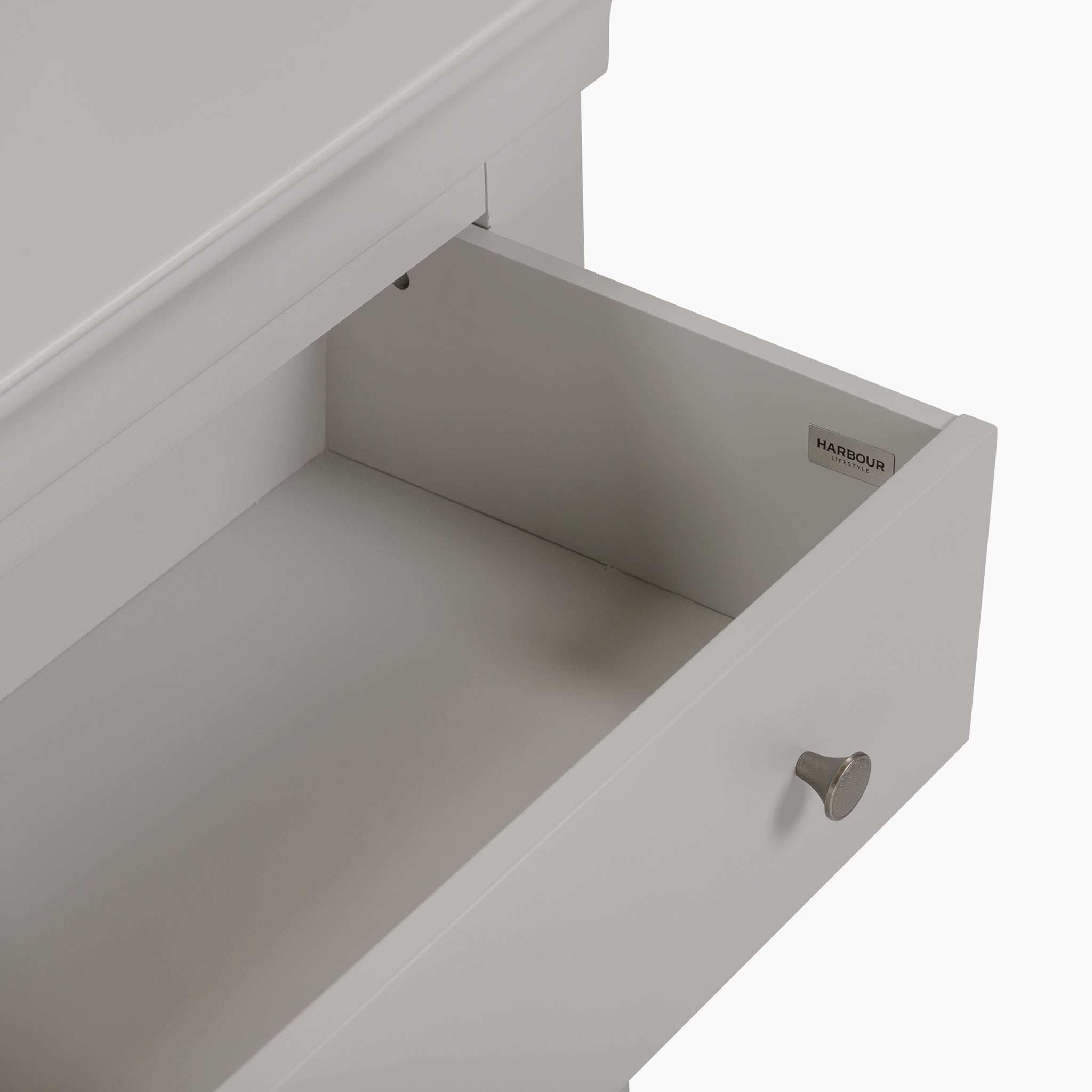 The Chalbury 3 Drawer Chest in Pebble Grey includes an open white drawer adorned with a silver knob, effortlessly complementing the elegant storage furniture.