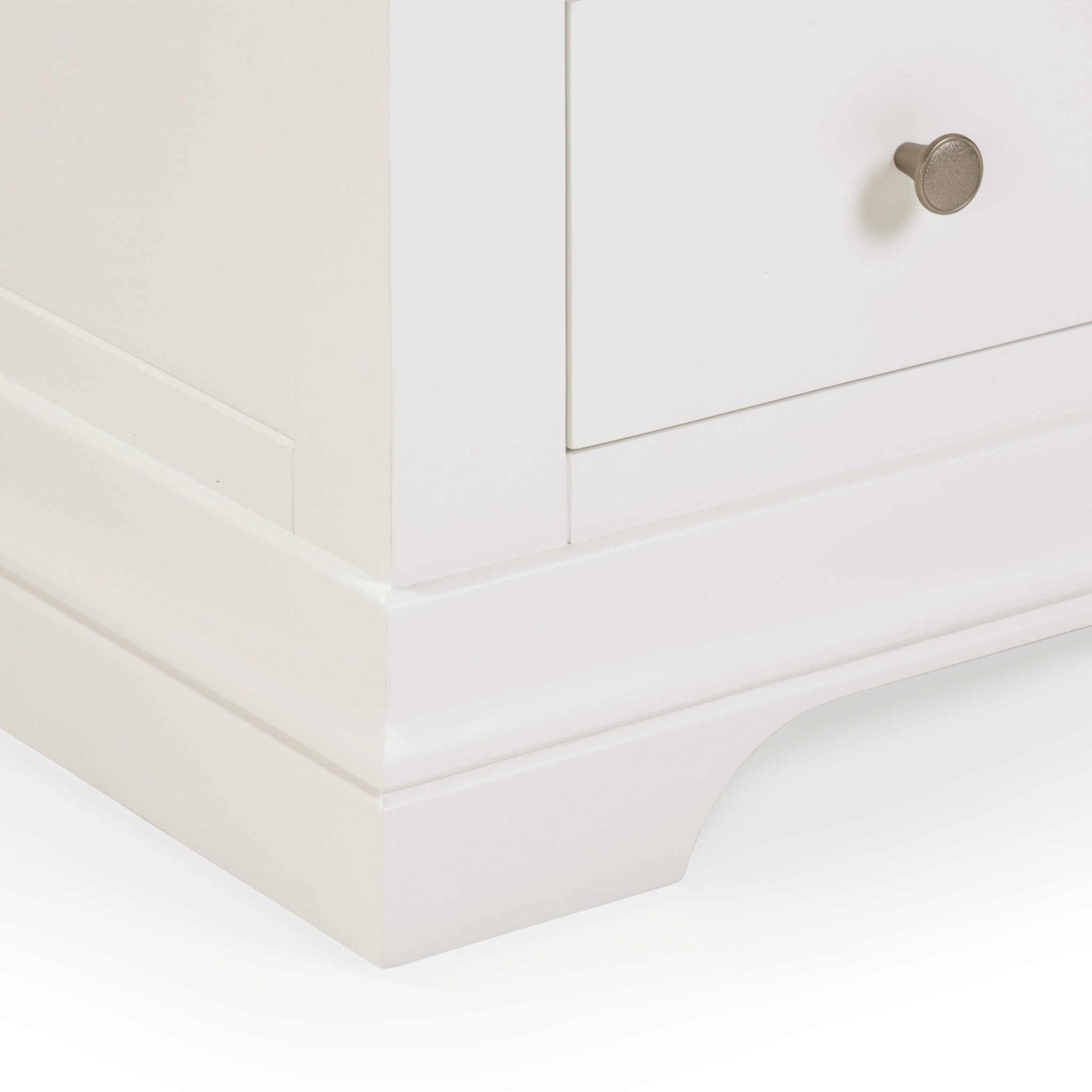 Close-up of the Chalbury 3 Drawer Chest in Warm White, showcasing its corner with a small round metal knob and decorative base.