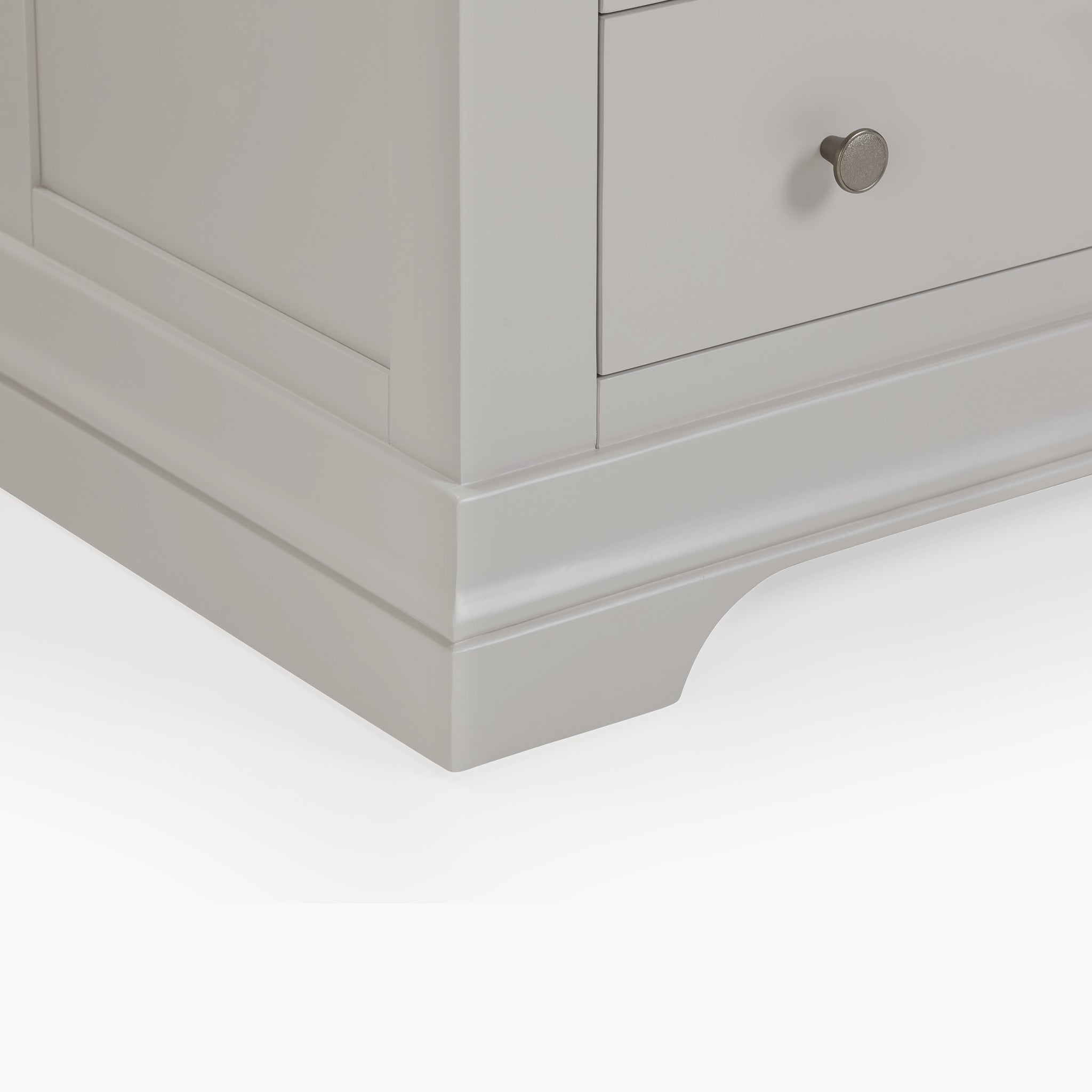 Close-up of the Chalbury 3 Over 4 Chest of Drawers in Pebble Grey, highlighting a drawer with a round silver knob and elegant storage furniture details like the smooth base and corner finish.