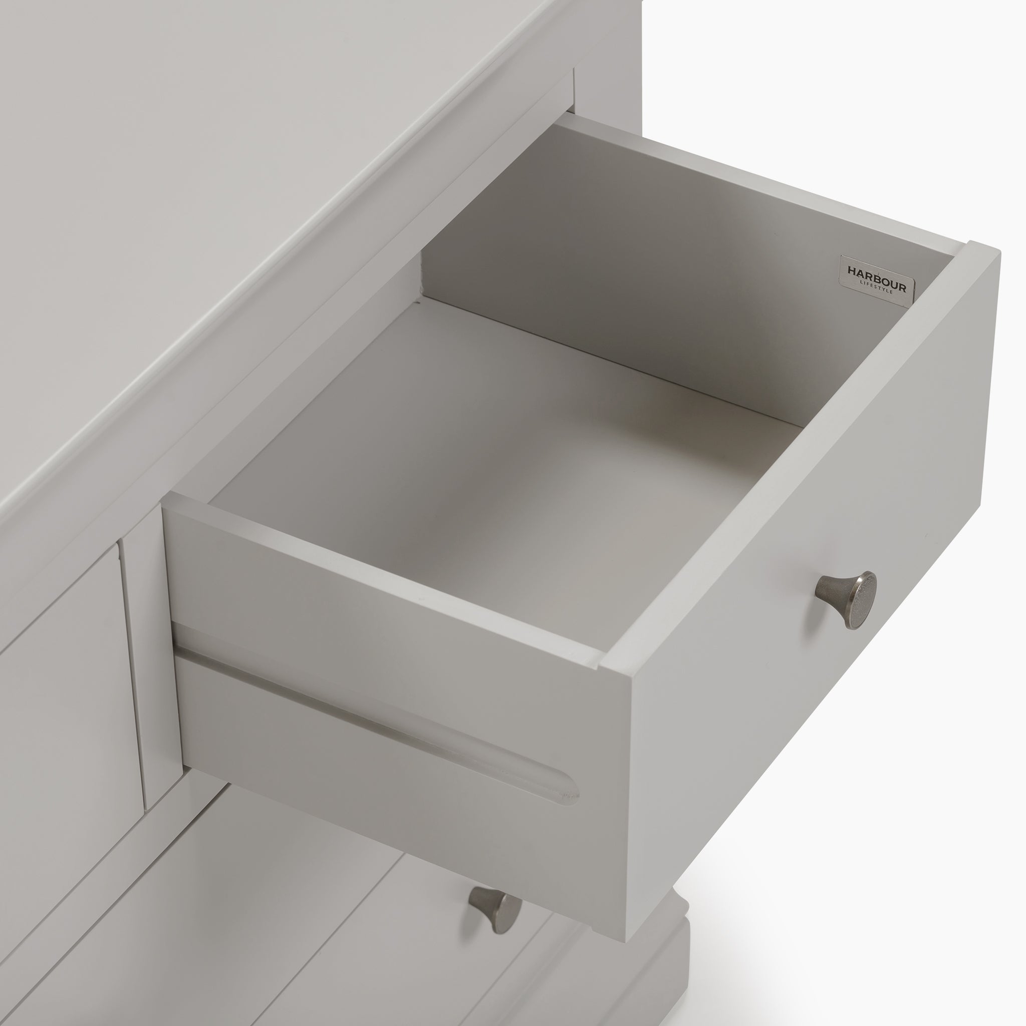 Open the pebble gray drawer with a metal handle, part of the Chalbury 3 Over 4 Chest of Drawers in Pebble Grey, a seamless storage solution that perfectly complements your space.