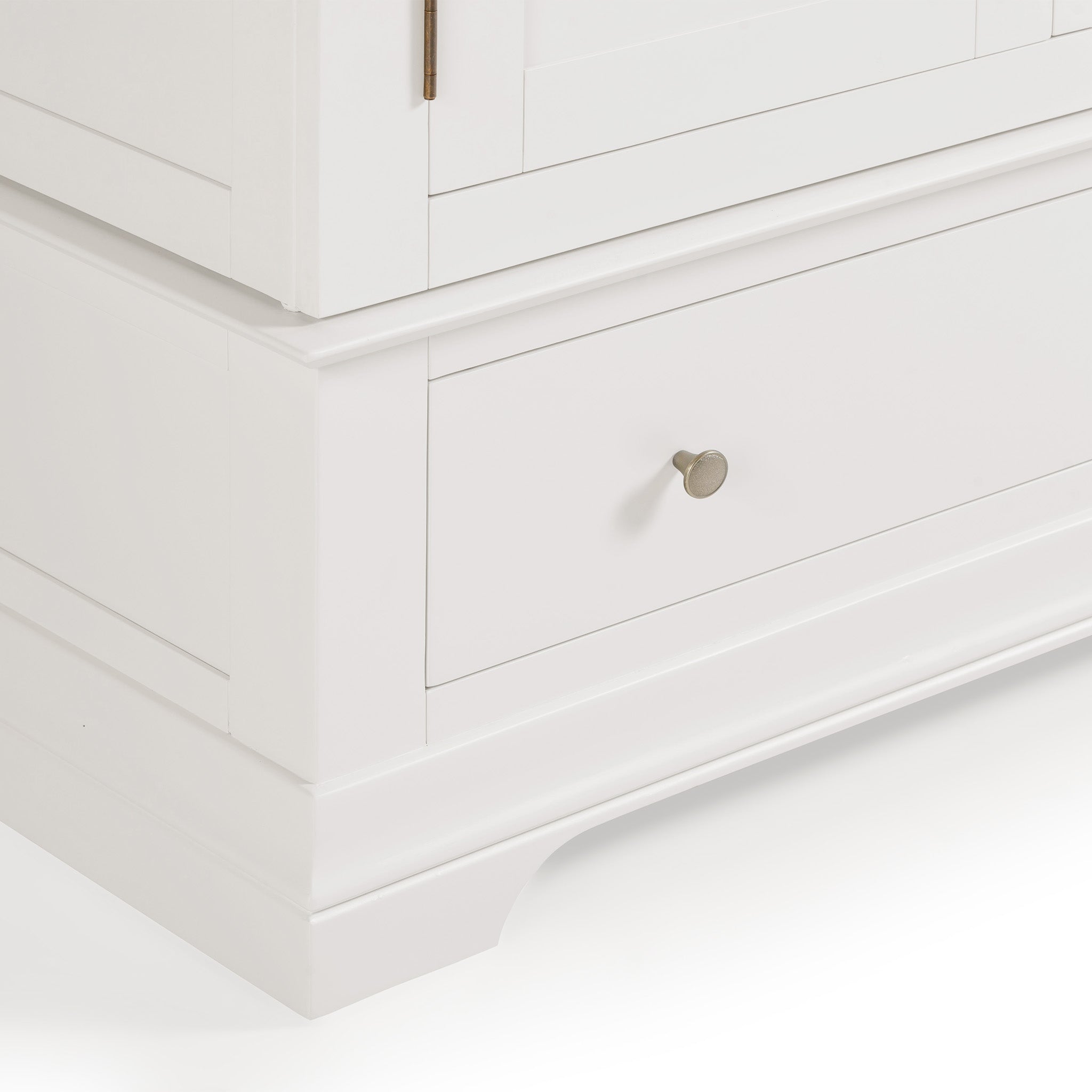 A close-up of the Chalbury Double Wardrobe in Warm White reveals its sleek design, showcasing a white wooden cabinet with a silver knob on the drawer, embodying contemporary style and providing ample storage with its smooth finish.