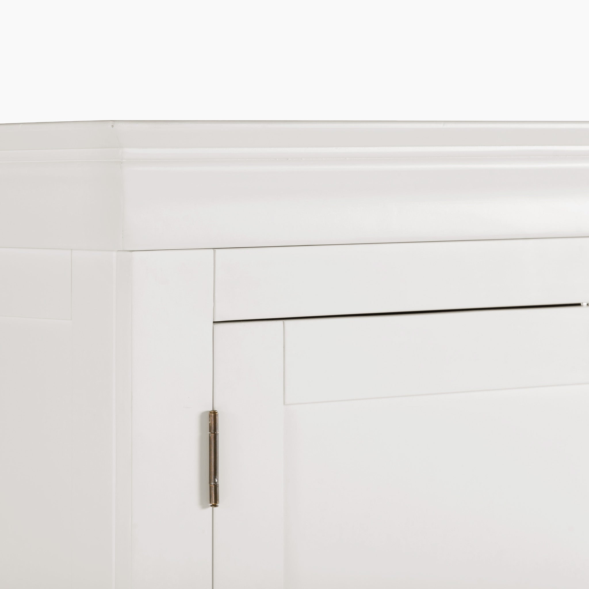 Close-up of a cabinet corner in warm white with a visible door hinge, highlighting the contemporary design of the Chalbury Double Wardrobe.