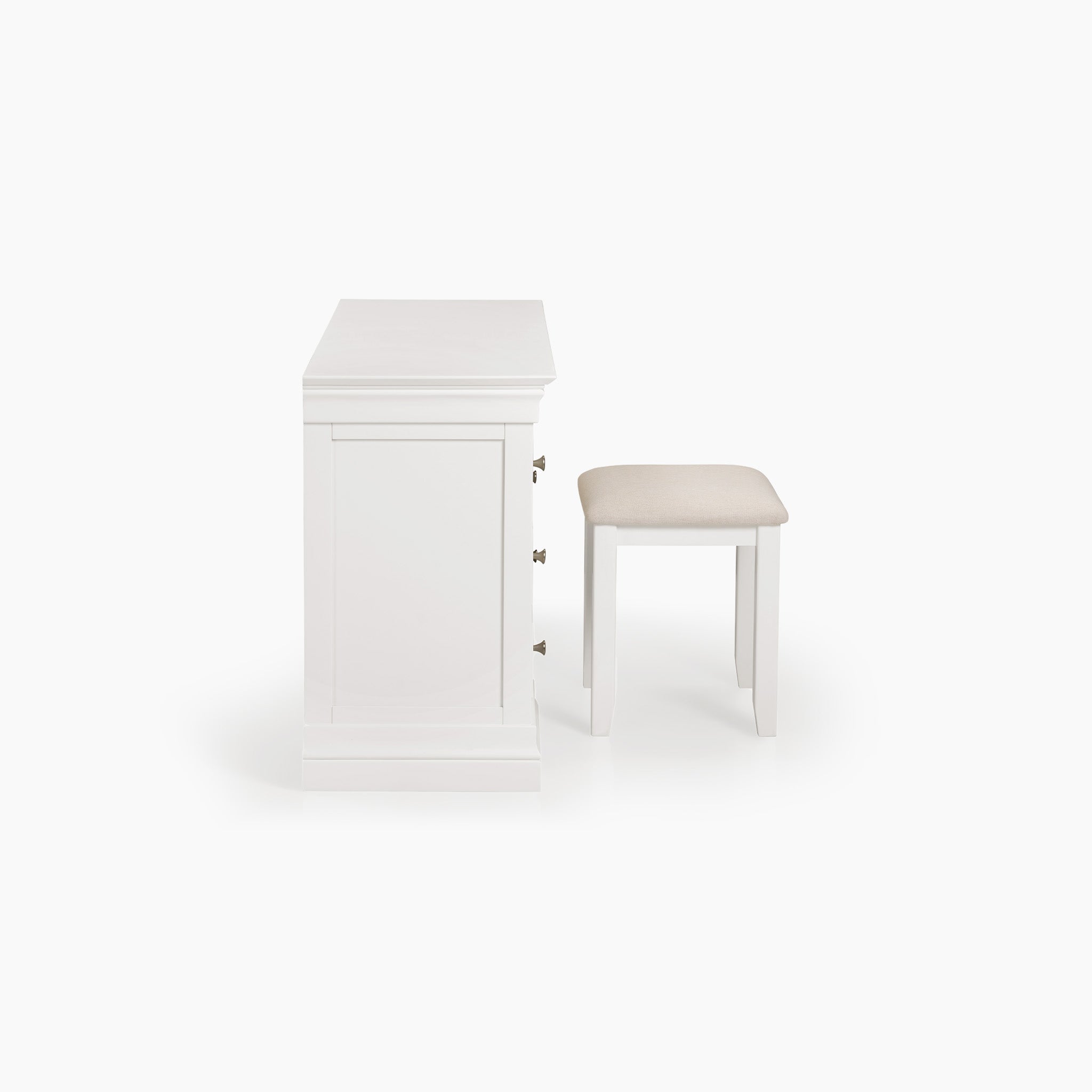 The Chalbury Dressing Table with Drawers in Warm White showcases a closed drawer design and comes with a beige cushioned stool, all set against a pristine white background.