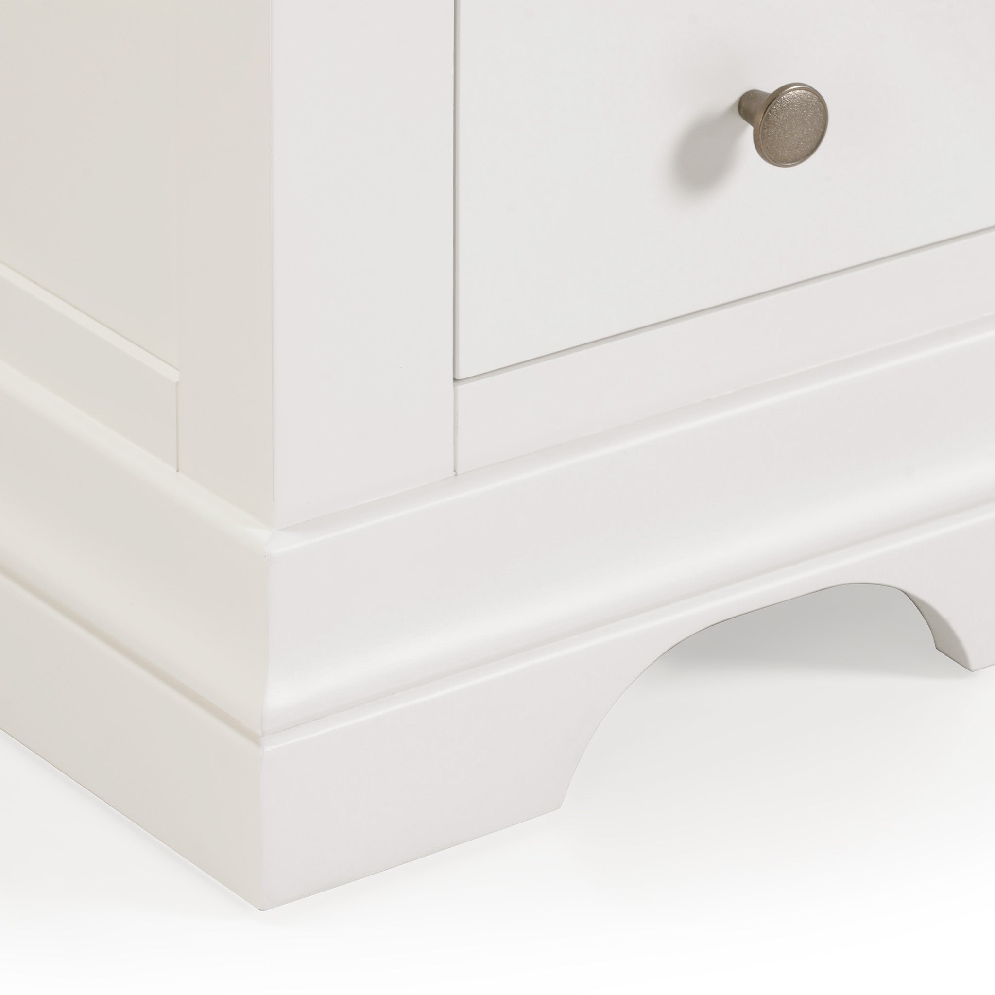 Close-up of the Chalbury Dressing Table with Drawers in Warm White, highlighting a corner of the white dresser with a drawer and round metallic knob, accentuated by its elegantly curved base design.