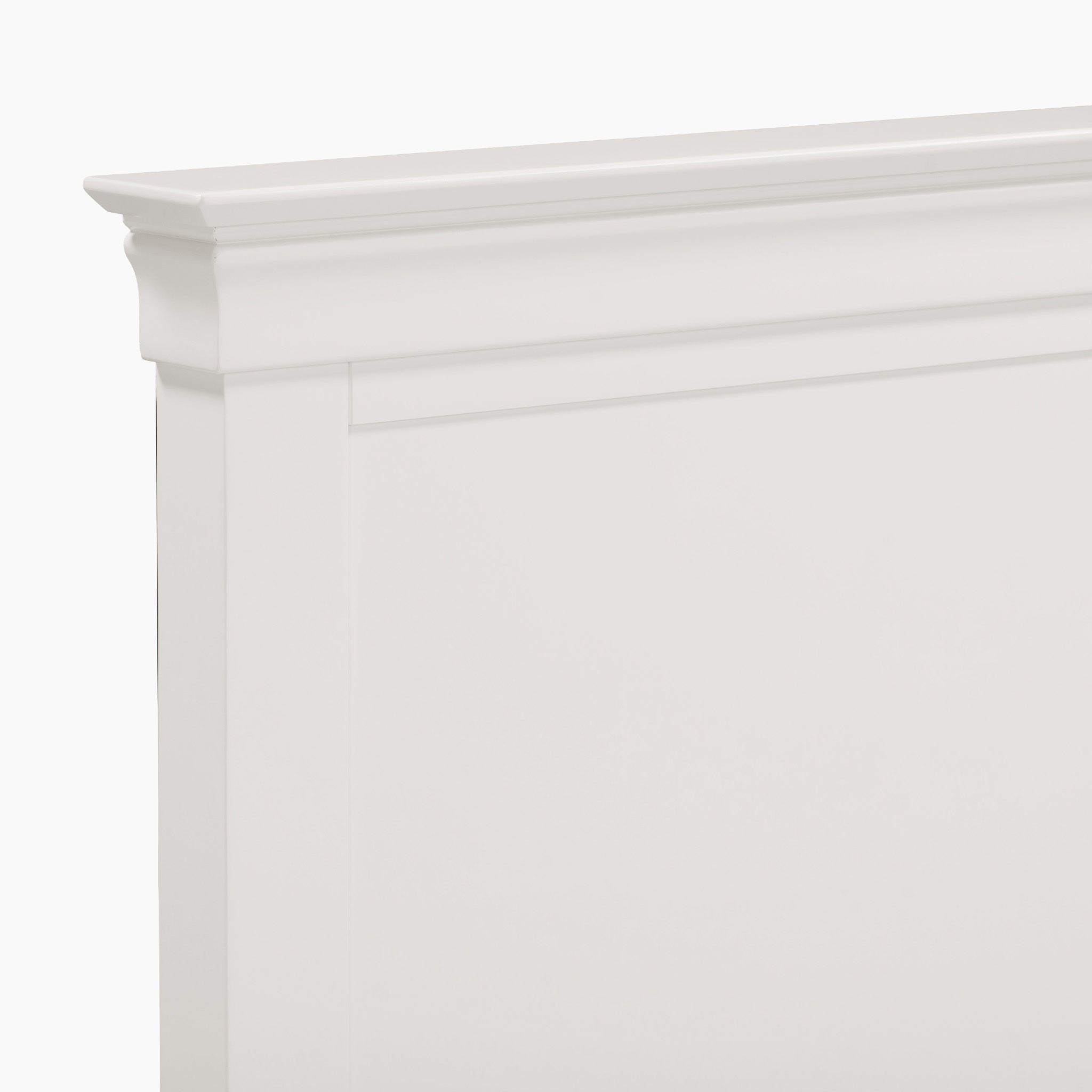 Close-up of the Chalbury 3ft High-End Single Bed Frame, featuring a white wooden headboard with simple, elegant molding and a smooth finish that radiates a warm white hue.