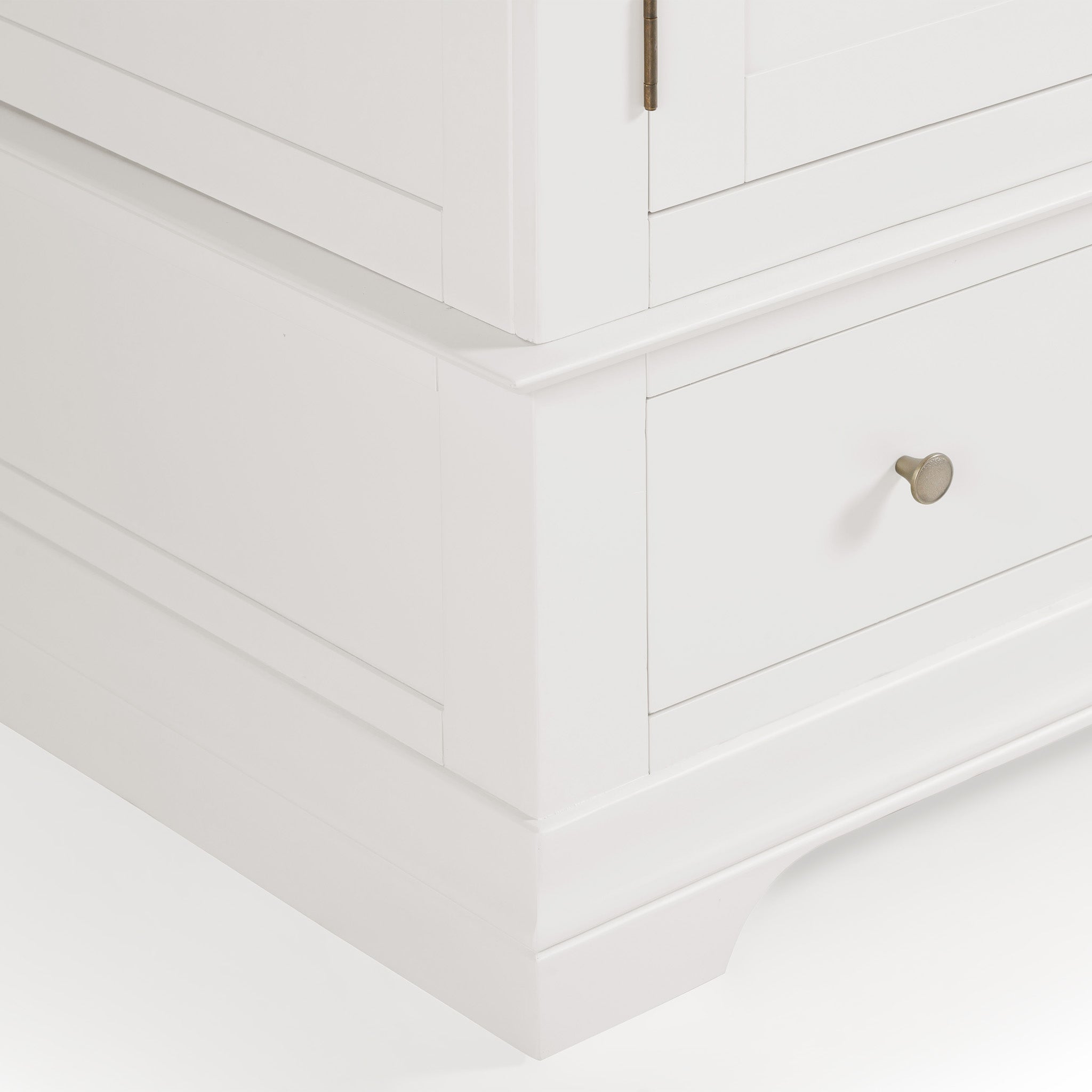 Close-up of a corner of the Chalbury Triple Wardrobe in warm white, showcasing a single drawer with a round metallic knob that enhances its contemporary design.