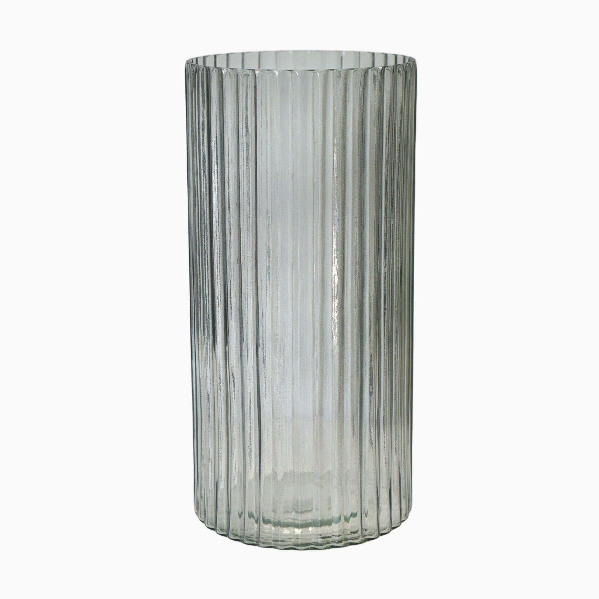 The Daphne Ribbed Vase in Clear features a cylindrical shape and is set against a white background, inspired by the design of the 1960s.