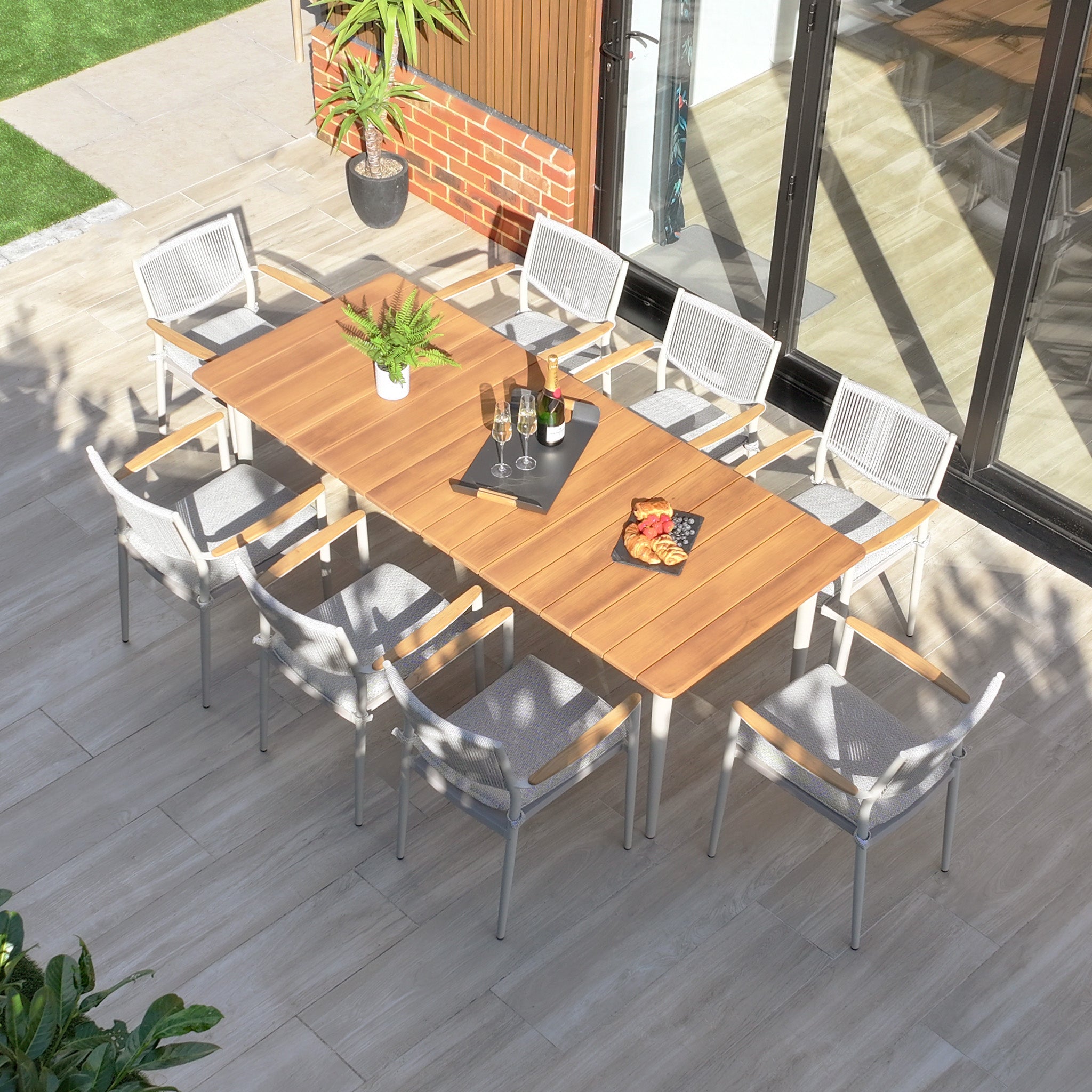 Aerial view of the Tellaro 8 Seat Rectangular Dining Set with a weather-resistant teak table in Latte, ideal for drinks and snacks on a tiled patio.