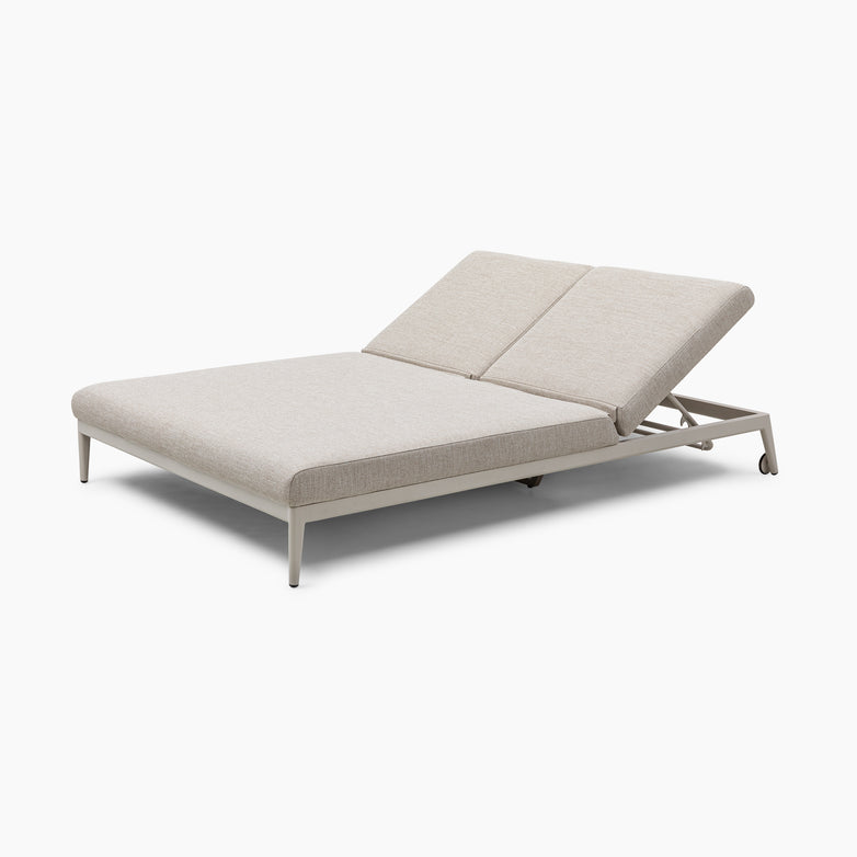 The Luna Outdoor Fabric Double Sun Lounger in Fawn, featuring a modern adjustable design with a sturdy metal frame and upholstered in Luna outdoor fabric, is perfect for all-weather conditions and is elegantly displayed against a pristine white background.