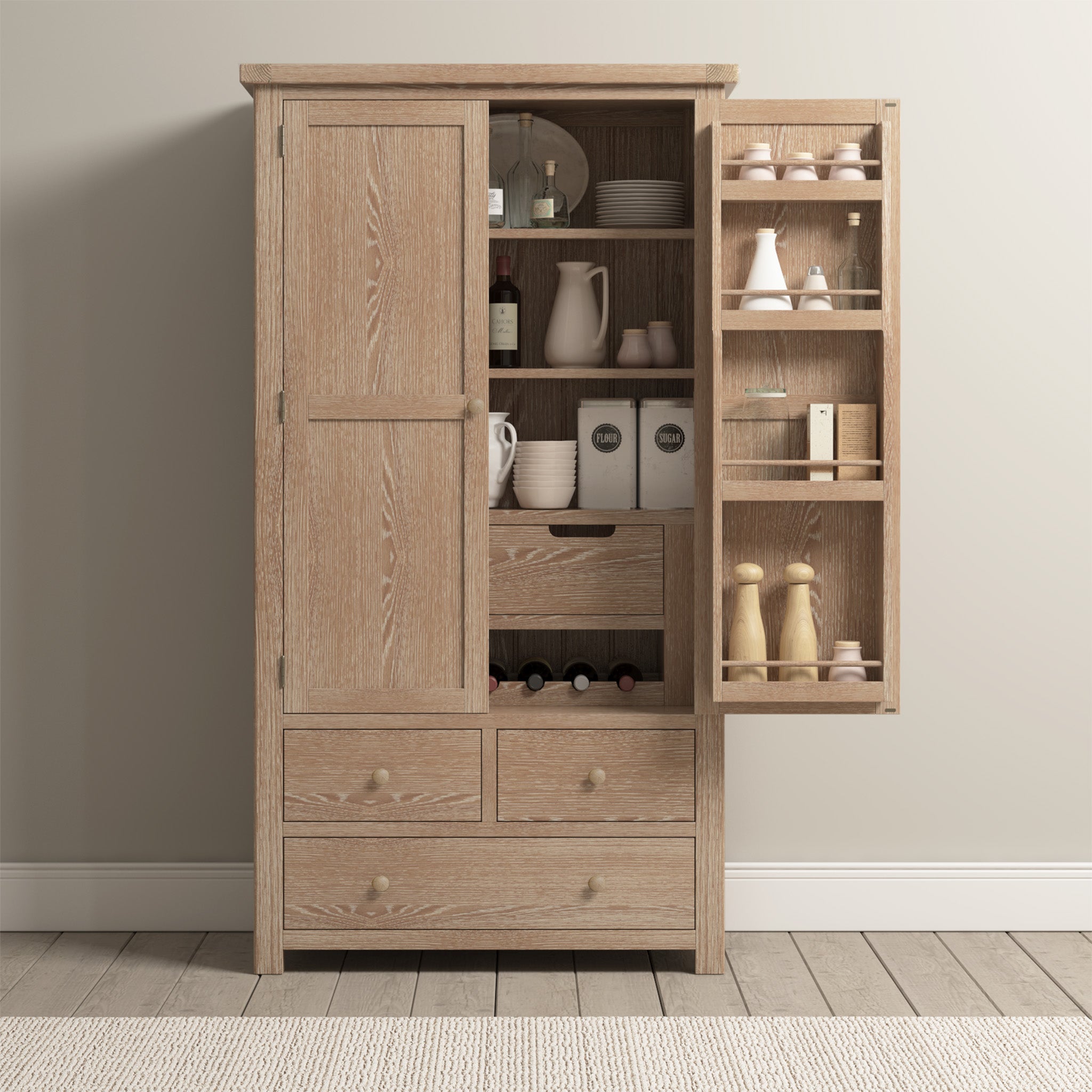 The Burford Double Larder Unit in Natural Oak showcases an enchanting wooden kitchen cupboard with its door ajar, displaying shelves stocked with dishes, jars, and spices. Its rustic design harmonizes beautifully with the light wood floor and beige walls, fostering a warm and inviting ambiance.