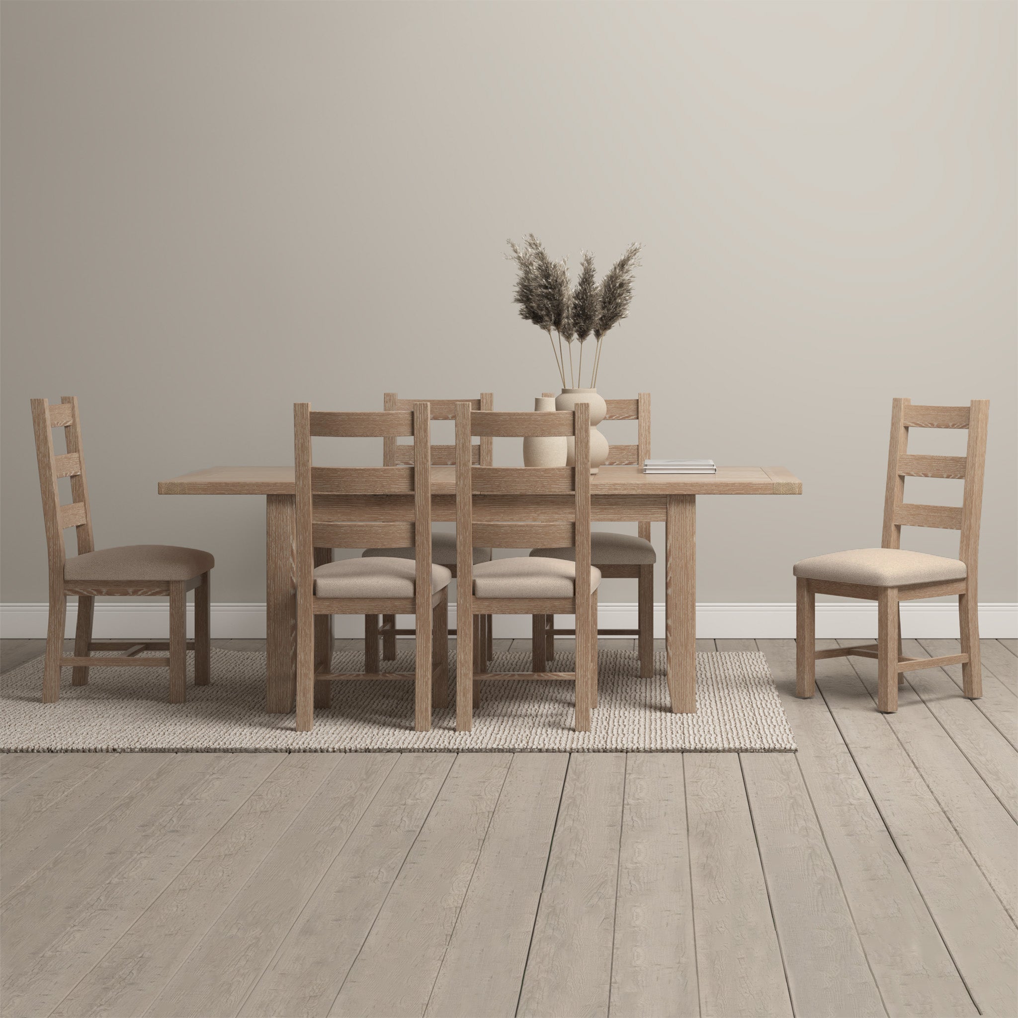 The minimalist room is elegantly arranged with the Burford 4-6 Seater Extending Dining Table in Natural Oak, accompanied by chairs, a beige rug, and a pampas grass centerpiece. The table's extending feature makes it ideal for hosting both intimate dinners and larger gatherings.