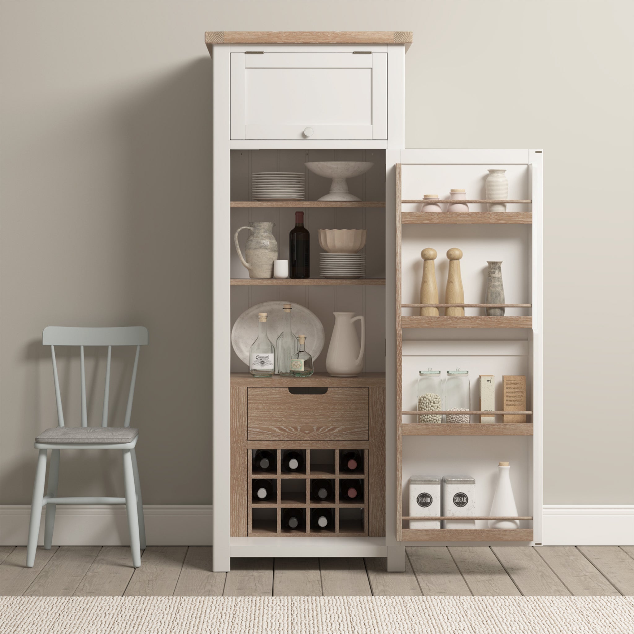 The Burford Single Larder Unit in Warm White is a storage cabinet featuring an open door that reveals dishes, bottles, and a wine rack, all beautifully enhanced by natural oak finishes. Next to it is a gray chair, providing both style and practicality for your kitchen storage needs.