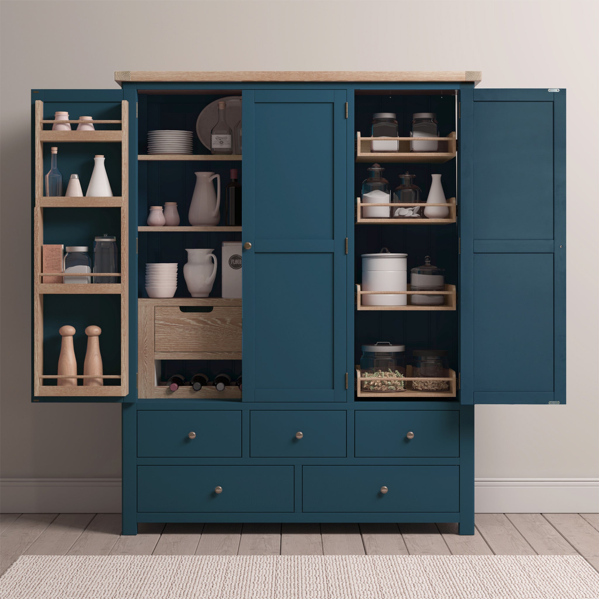 The Burford Triple Larder Unit in Navy Blue showcases open doors revealing shelves stocked with jars, dishes, and kitchen essentials. It includes an elegant oak top and soft-close drawers for sleek storage solutions.