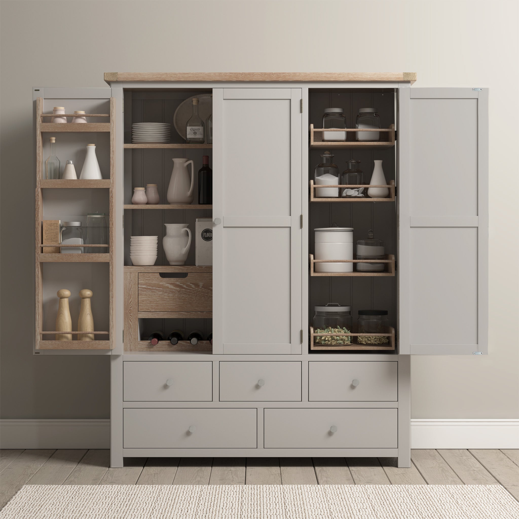 A Burford Triple Larder Unit in Pebble Grey stands with open doors, revealing shelves stocked with jars, dishes, spices, and wine bottles in a neutral-toned room—an elegant kitchen storage solution for the modern home.