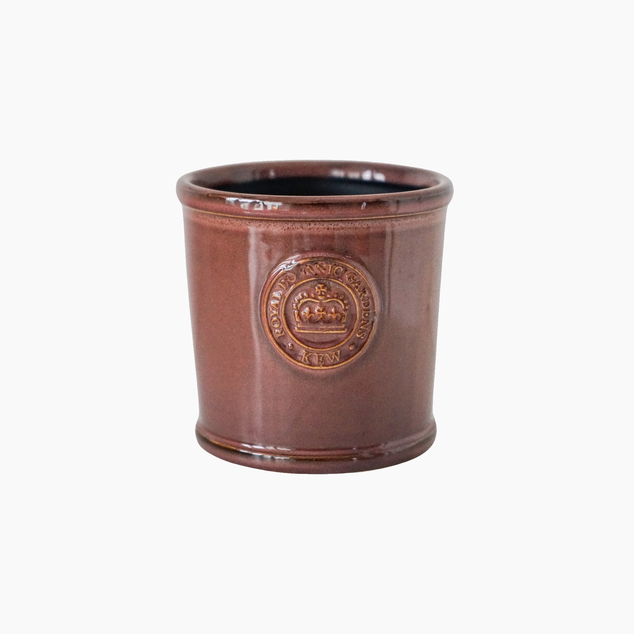 The Ivyline Kew Reactive Glaze Plum Planter, featuring a brown ceramic body with an embossed emblem, echoes the elegant designs of Kew Gardens. Its unique glaze makes it perfect for stylish houseplants, set against a crisp white background.