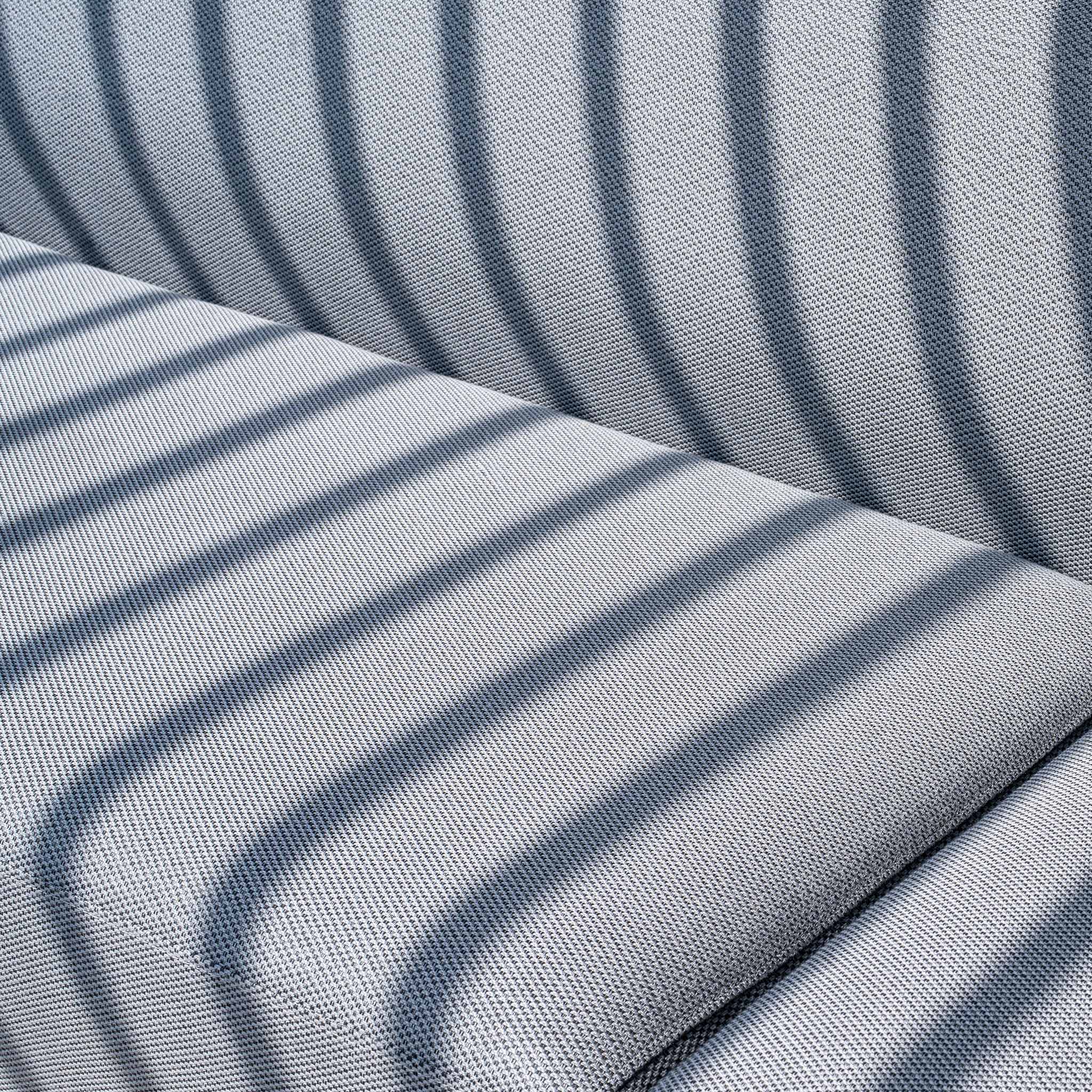 Close-up of the Luna U-Shape Outdoor Fabric Sofa Set with Firepit Coffee Table in Grey, showcasing its outdoor fabric upholstery featuring diagonal light and shadow stripes pattern on a cushioned surface.