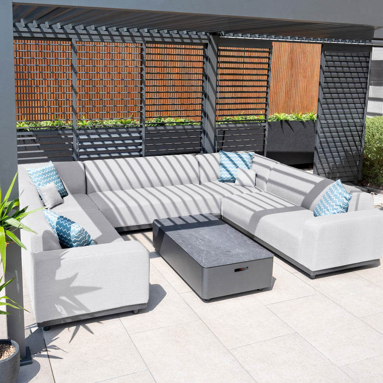 Outdoor patio with the Luna U-Shape Outdoor Fabric Sofa Set in Oyster Grey, featuring blue and white quick-dry foam cushions, all under a pergola.