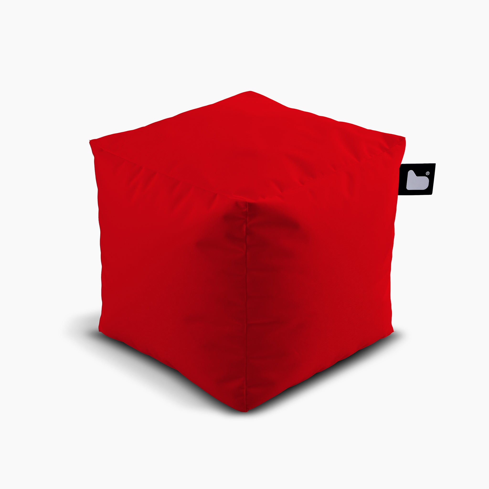 Introducing the Outdoor B-Box in Red—a vibrant, waterproof bean bag in a stylish cube shape. It features a small black tag with a white heart icon and is perfect for extreme lounging. Designed to withstand the elements, it ensures ultimate comfort for outdoor relaxation.