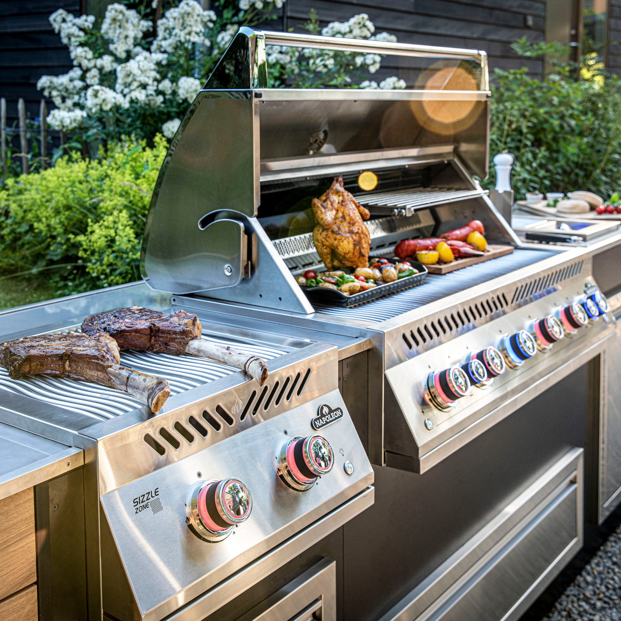 Enjoy a delicious meal of rotisserie chicken, grilled vegetables, and steaks on the Napoleon 700 Series 44" Built-in Gas Grill set in your garden patio.