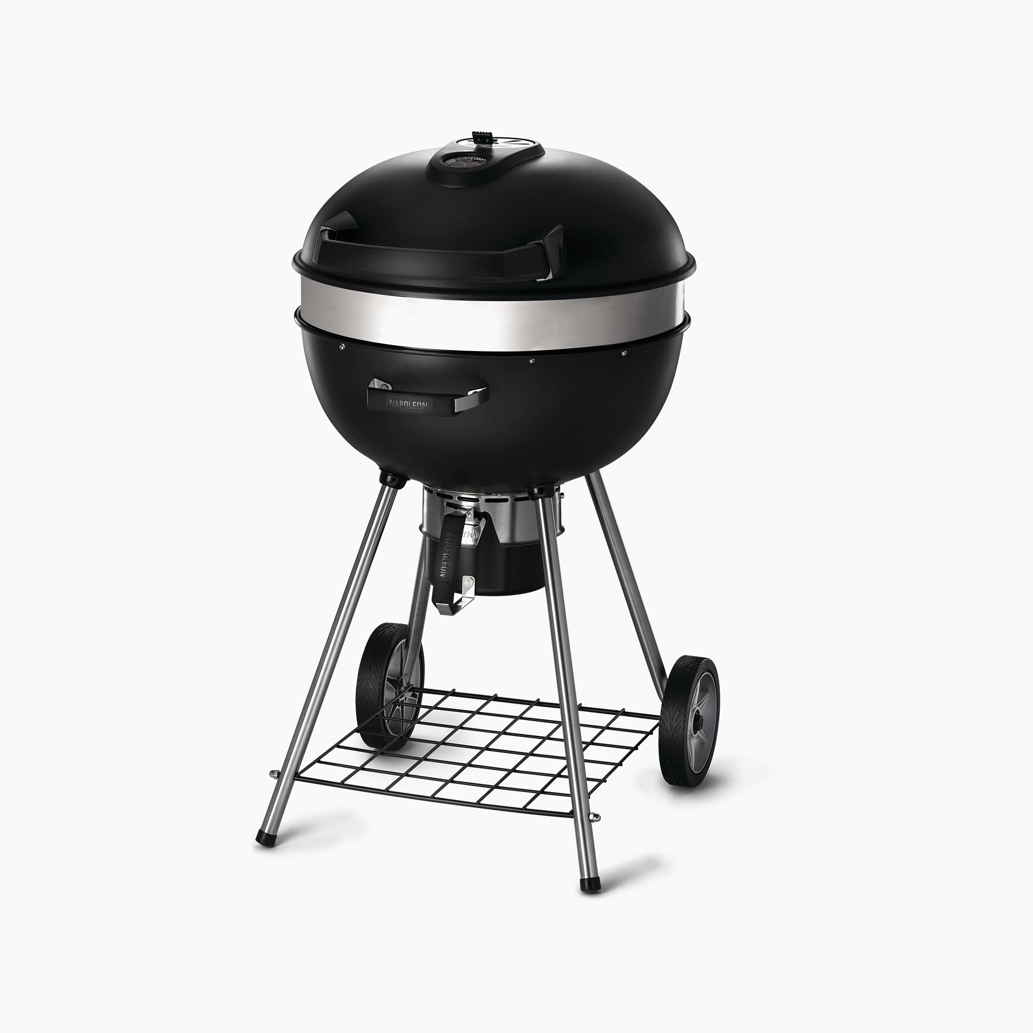 A Napoleon Pro Charcoal Kettle Grill in black, featuring wheels and a lower storage rack, designed for precise temperature control, set against a white background.