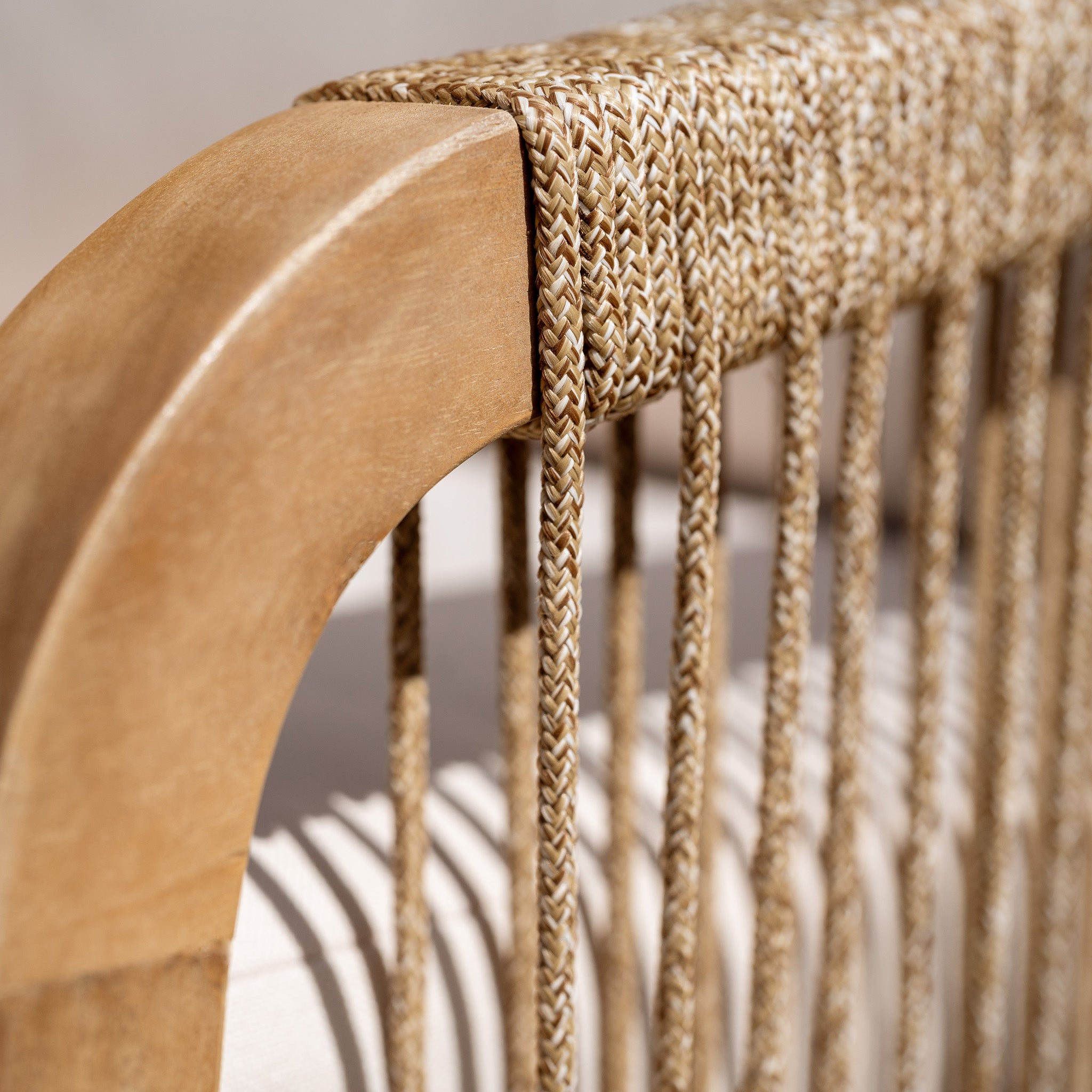 Close-up of woven detailing on a wooden chair from the Quay Corner Dining Set in Linen, featuring intricate beige rope patterns and a smooth, sustainably sourced acacia wood frame.