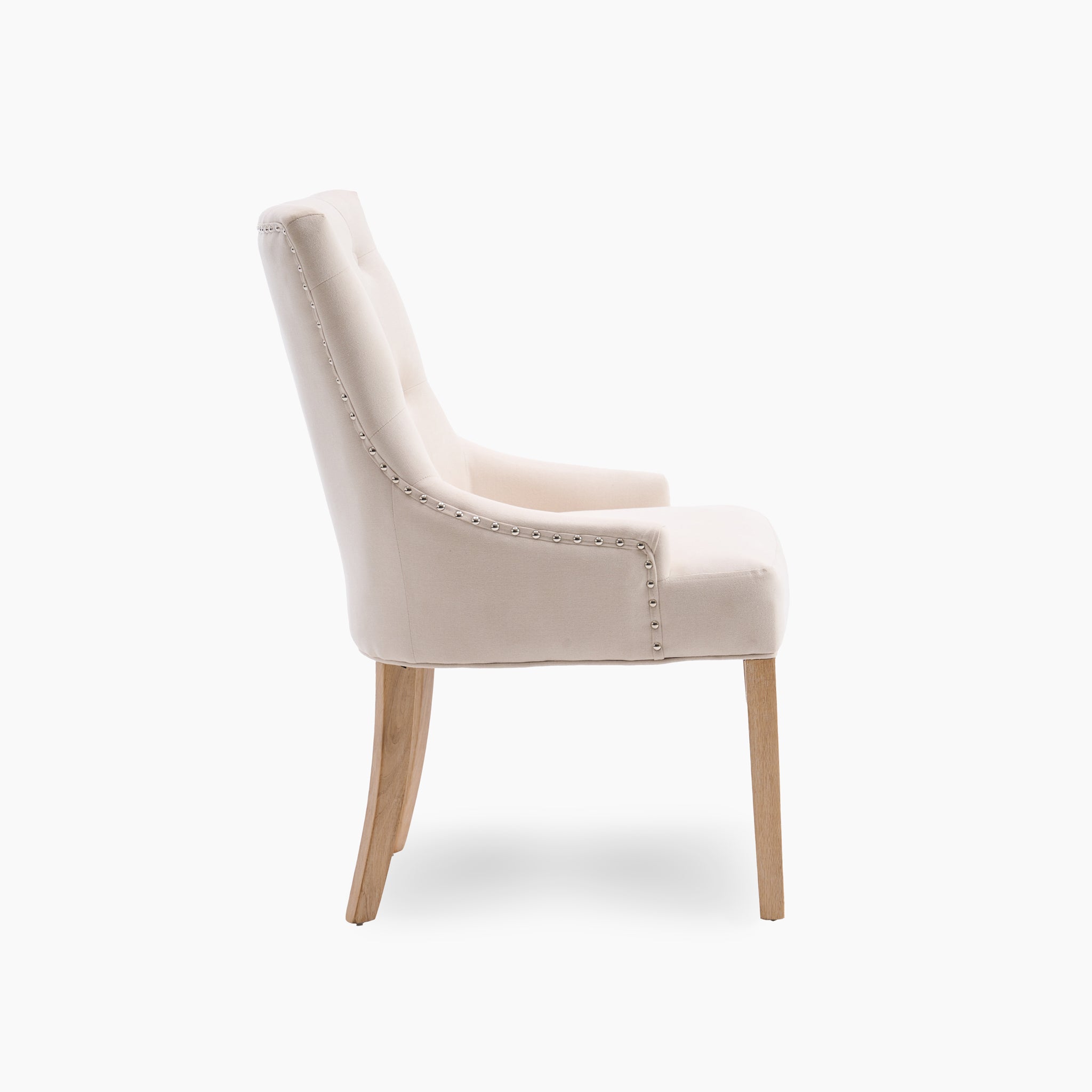 Side view of an ivory upholstered Regent chair from the set of two, showcasing elegant wooden legs and nailhead trim detailing.