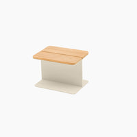 The Hatia Teak Side Table in Latte features a compact, contemporary design with a solid teak wood seat and a white metal base, making it an ideal choice for outdoor seating.