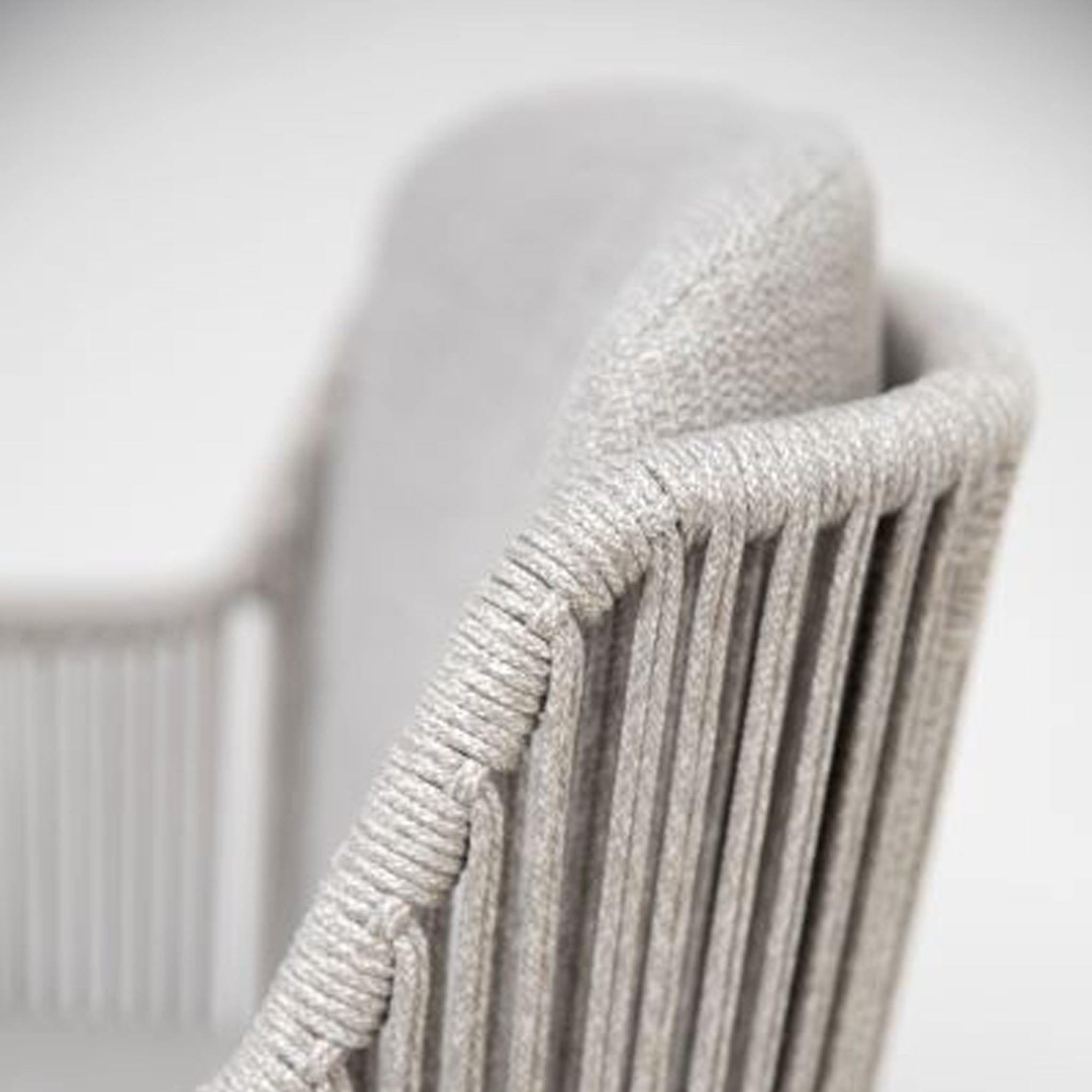 Close-up of a sleek, modern chair from the Bernini range, showcasing textured gray fabric and intricate rope detailing, perfectly complementing the Bernini 6 Seat Round Dining set with a Teak Table in Light Grey.