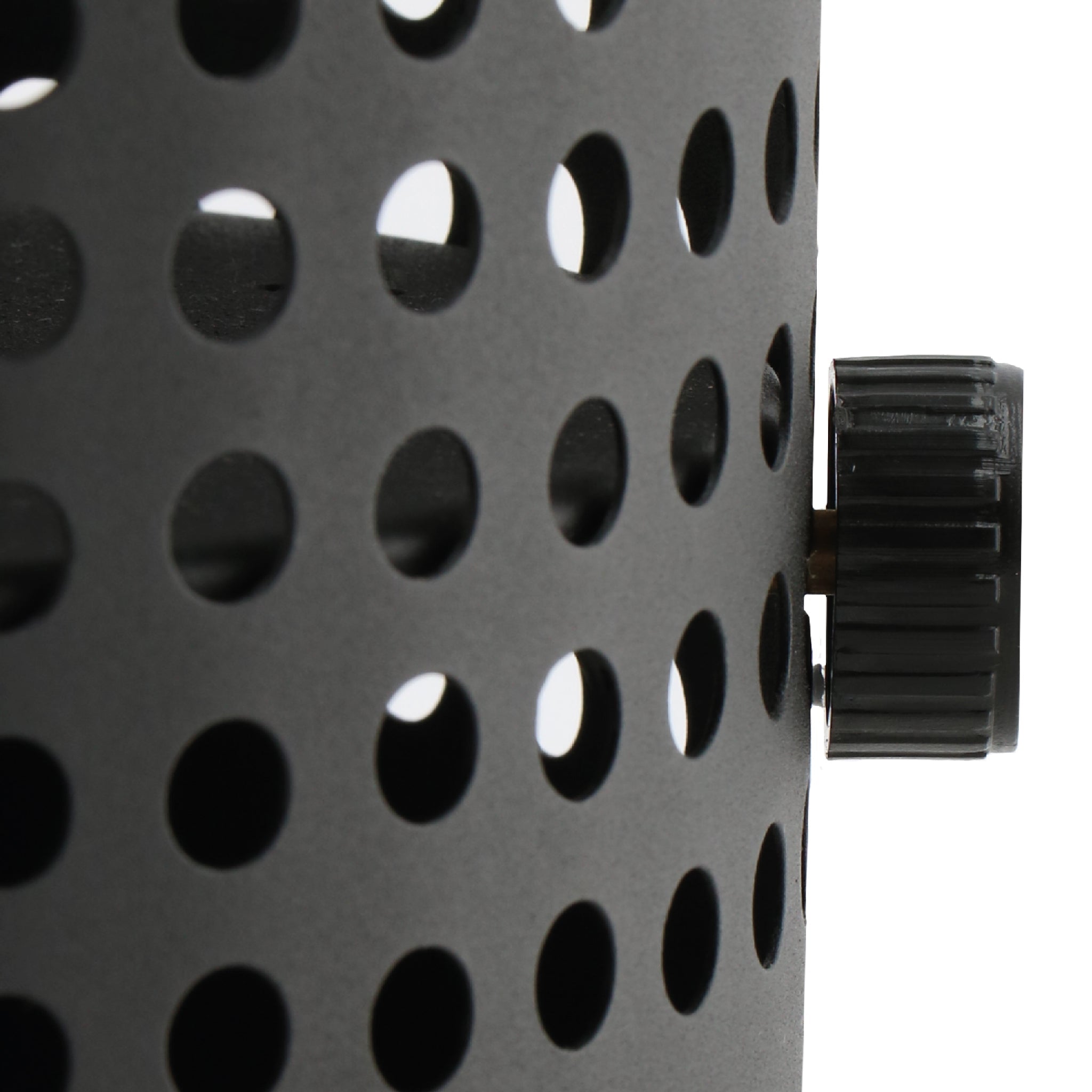 Close-up of a black perforated metal surface with circular holes and a black knob on the right side, showcasing the sleek design of the Cosiscoop Drop Lantern in Black to enhance your outdoor space.