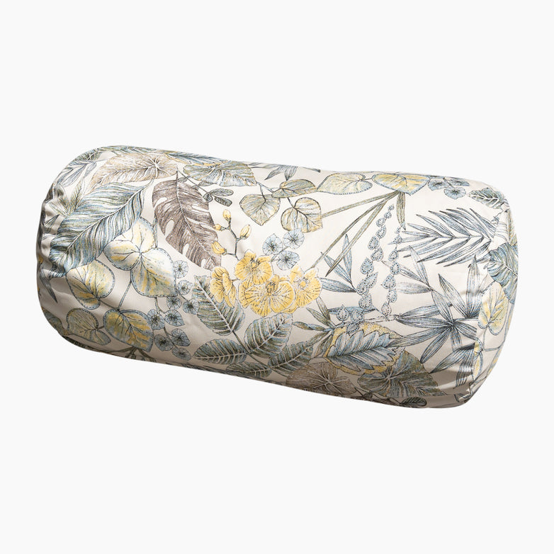 The Acrisol Bouquet Neutrals Large Round Bolster Floor Cushion (72cm x 35cm) showcases a botanical print with tropical leaves and flowers in muted yellow, green, and blue tones, making it an ideal addition to complement your outdoor scatter cushions.