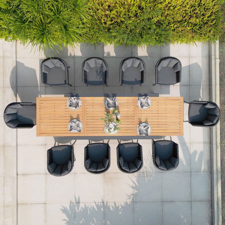 Top view of an outdoor dining area featuring a Harbour Lifestyle Palma 10 Seat Rope Extending Teak Dining Set in Grey, surrounded by black chairs on a tiled patio.